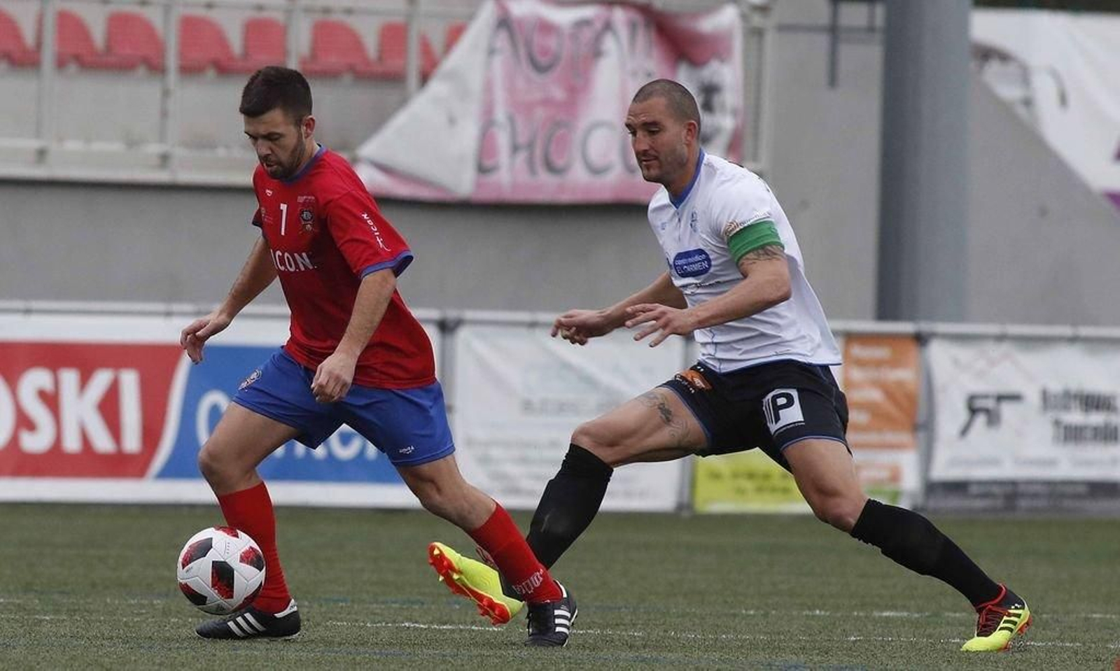 Comis protege un balón ante el acecho del capitán del Ourense CF y exjugador del Rápido Pedro García.