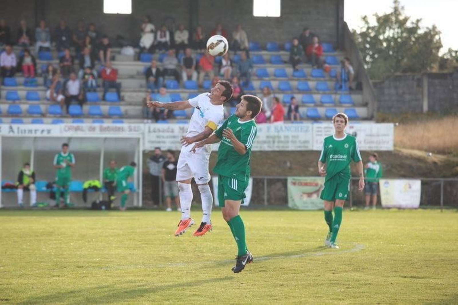 El capitán y delantero del Nogueira Oli salta a por un balón con Marcos Sotelo (JOSÉ PAZ)