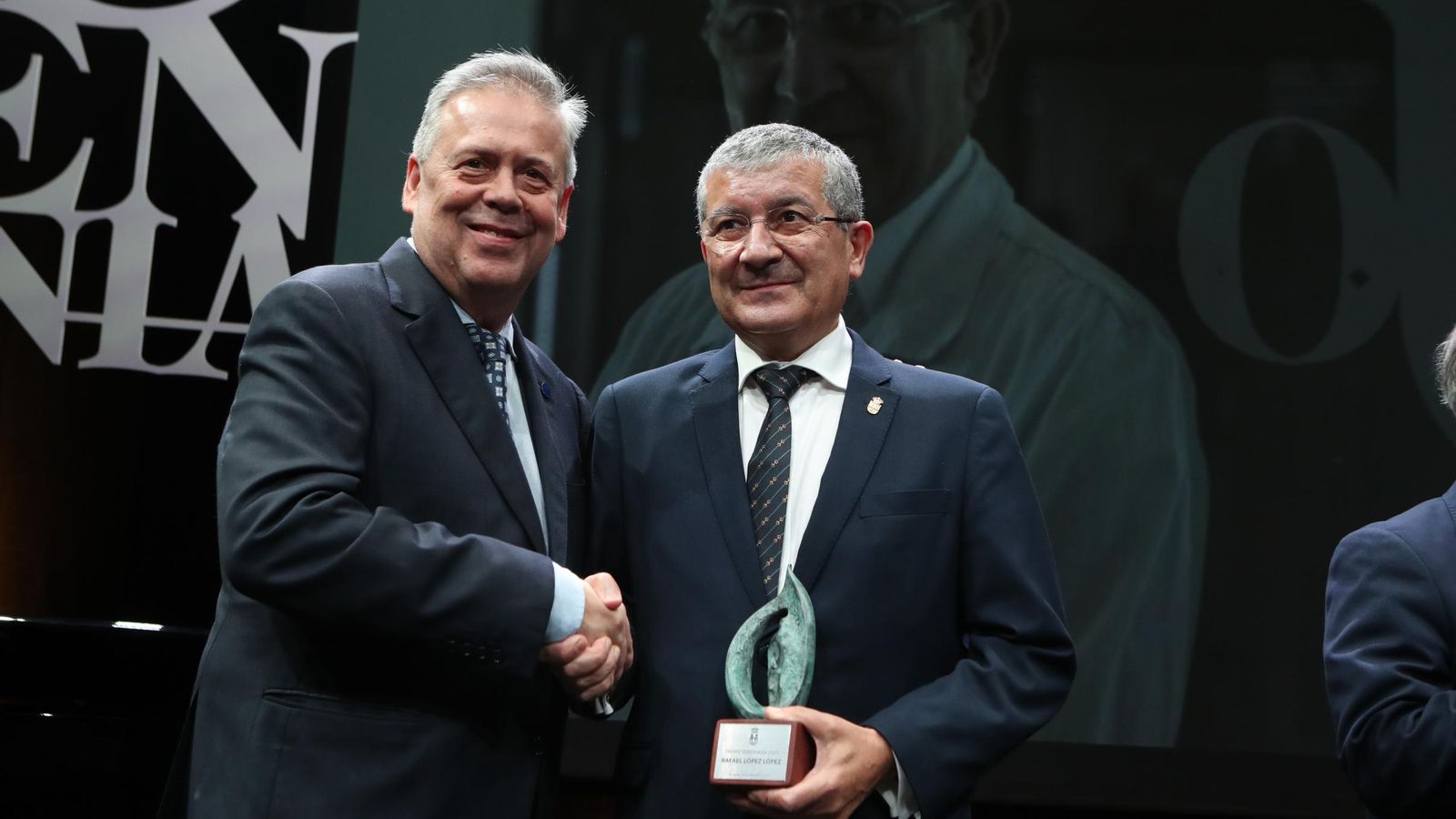 El conselleiro de Sanidade, Antonio Gómez Caamaño, saluda al premiado.