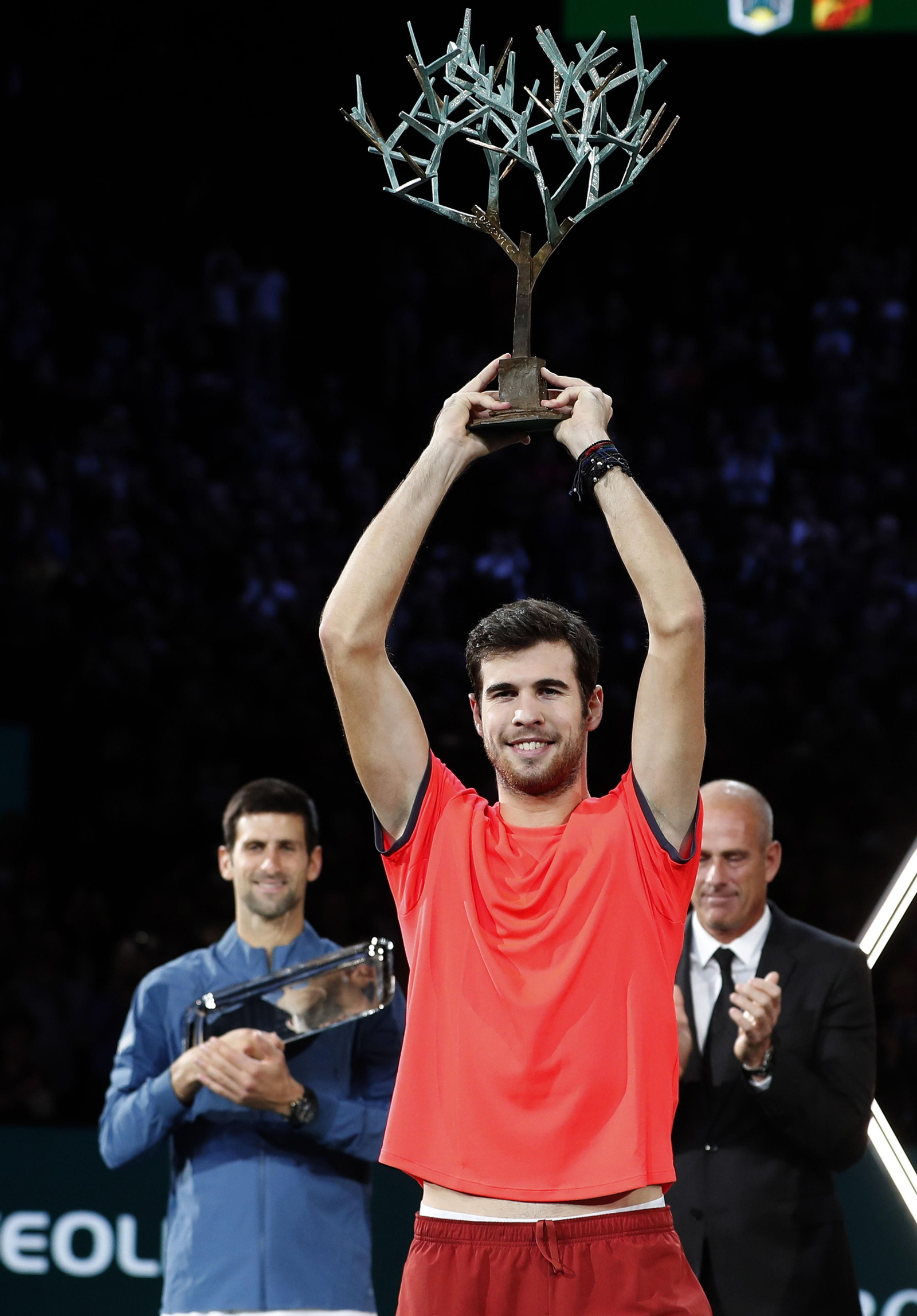 Khachanov celebra su título con Djokovic al fondo.
