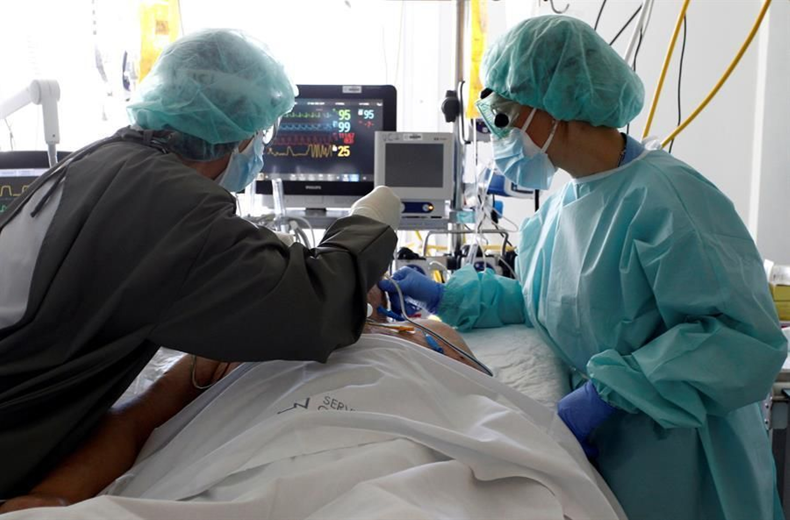 Varios sanitarios atienden a un paciente con COVID-19.