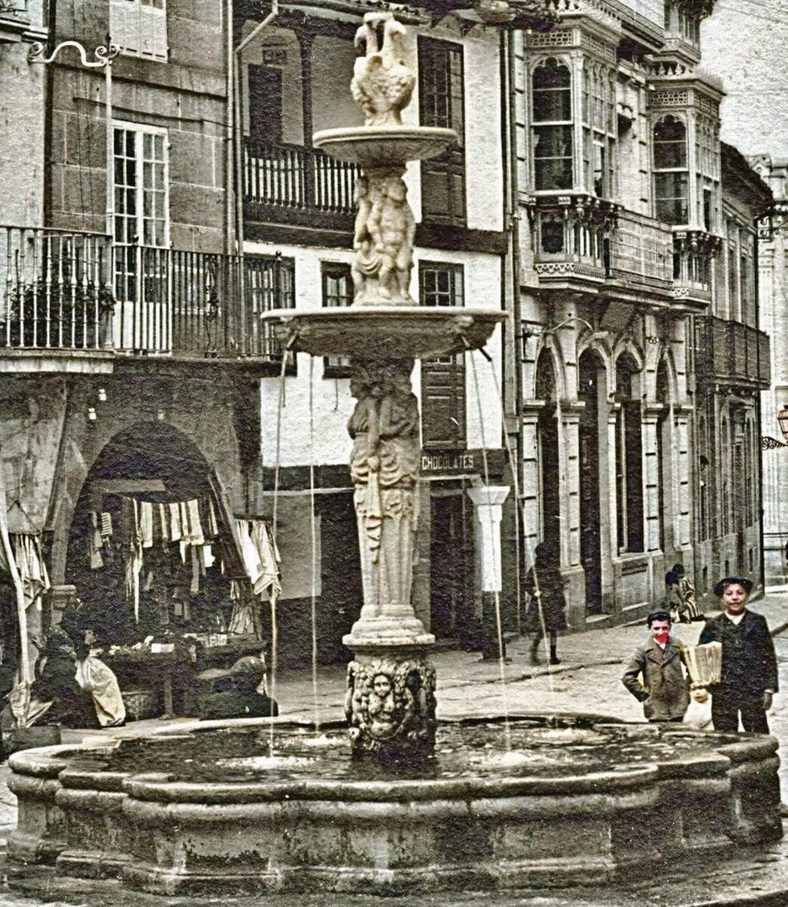 Mires la plaza, como la mires, la fuente preside...