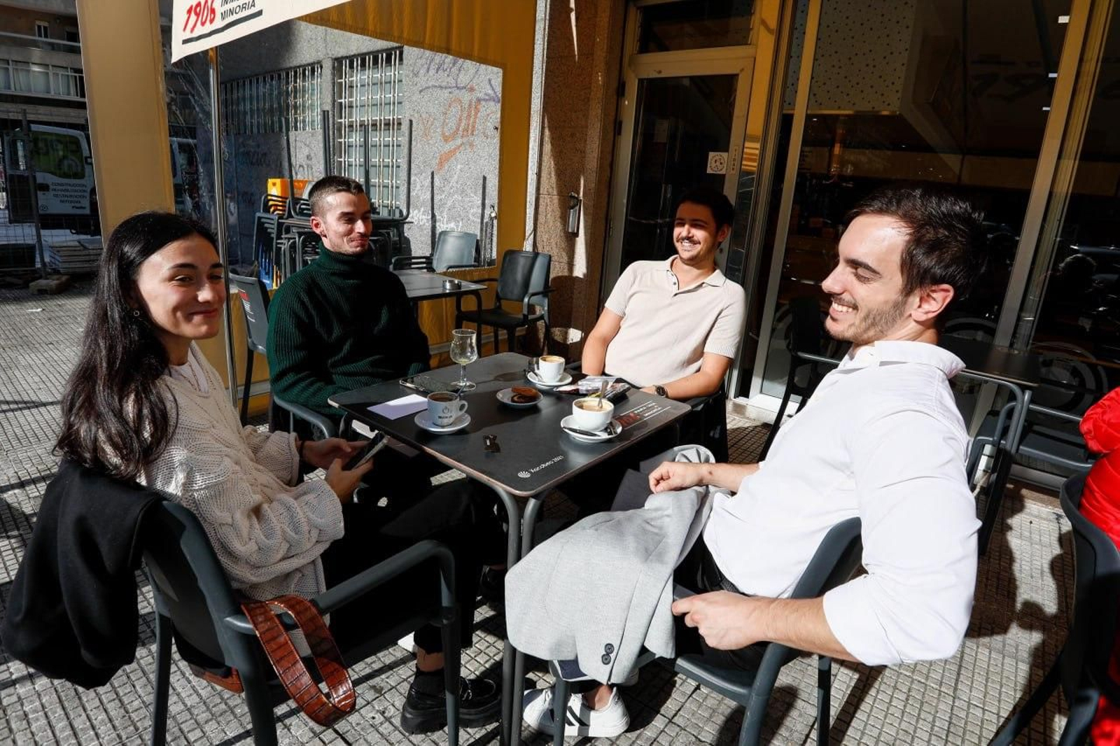 Un grupo de amigos disfruta del buen tiempo en una terraza.