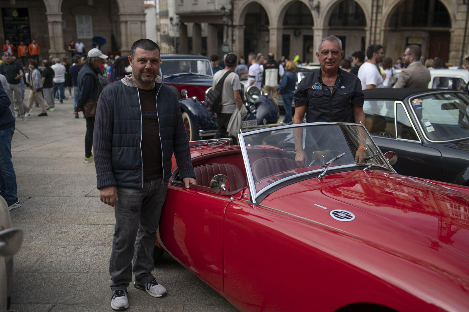 Dos personas posando con un coche de rally clásico para la foto