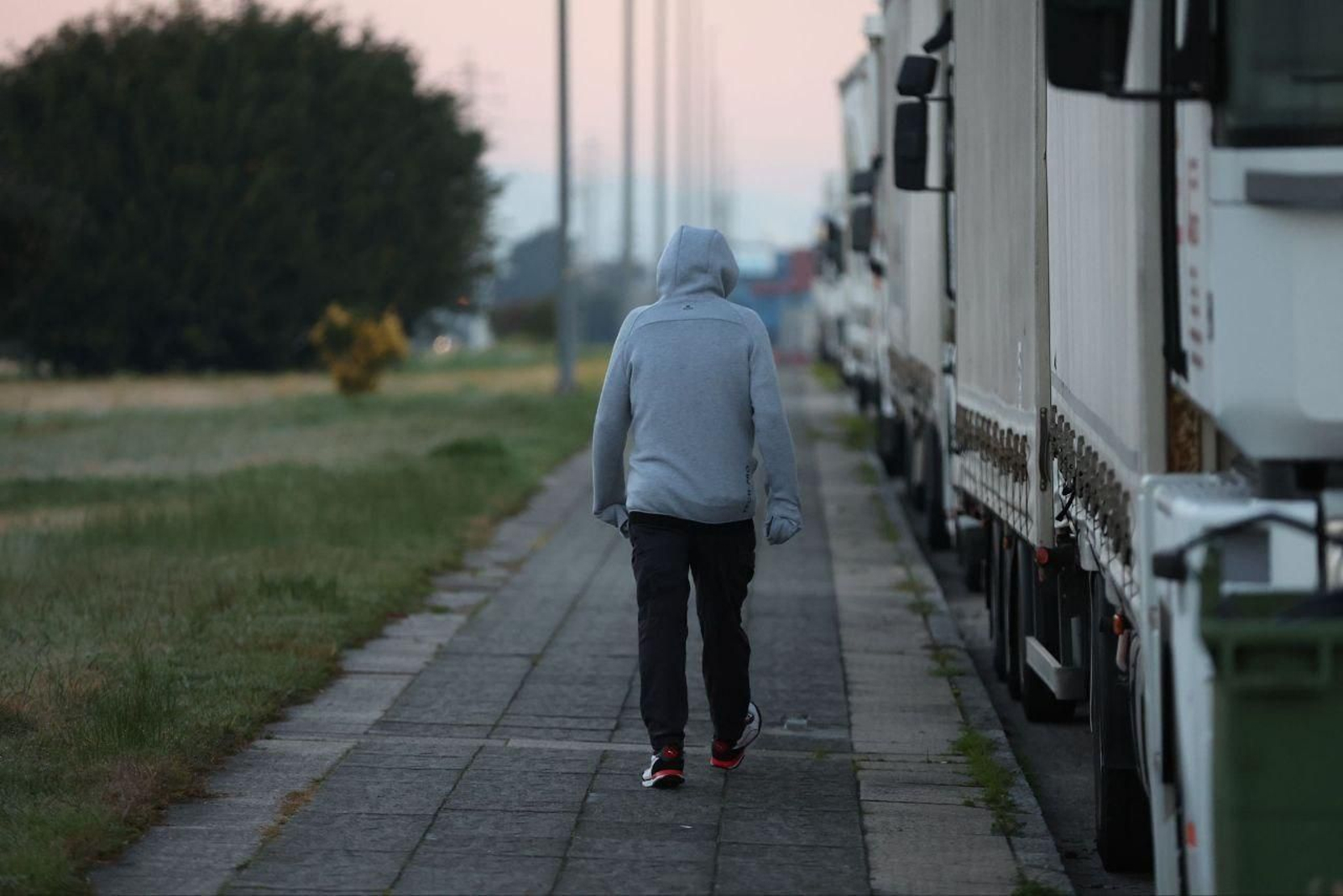 Un hombre camina cubriendo sus manos por el frío.