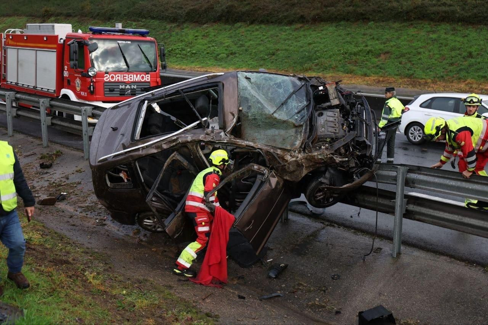 El vehículo destrozado y encima del quitamiedos.