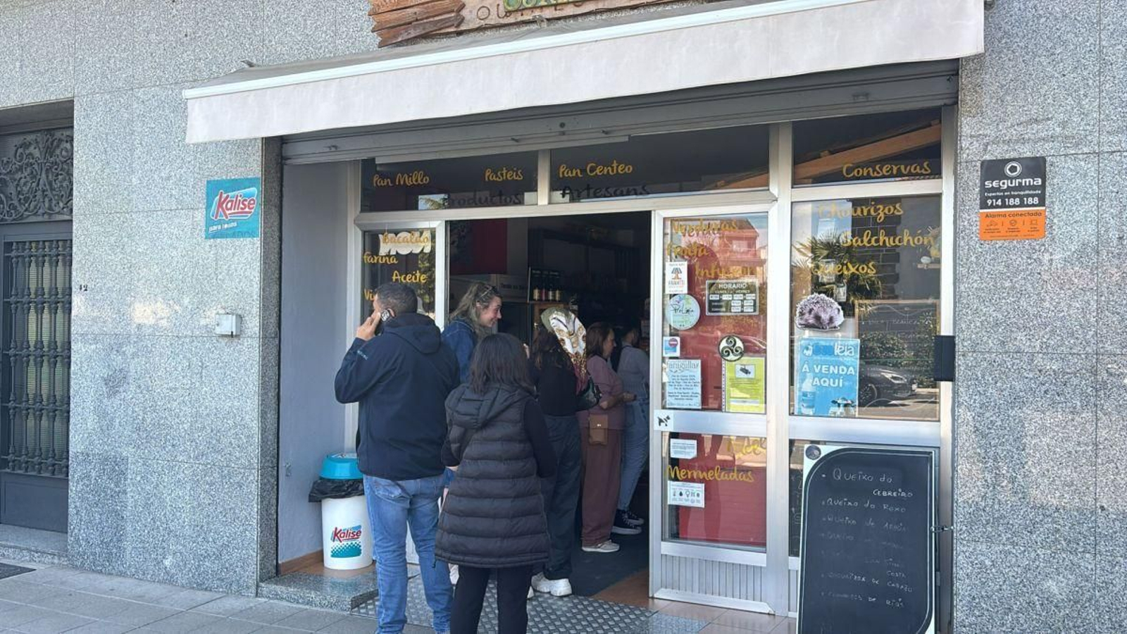 Supermercado en Xinzo con gente agolpándose a la puerta para comprar alimentos.