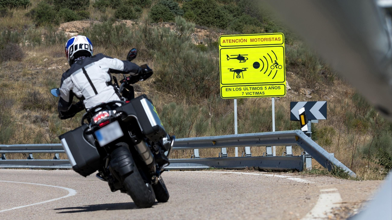 Un motorista frente a una señal que pretende concienciar sobre la mortalidad.