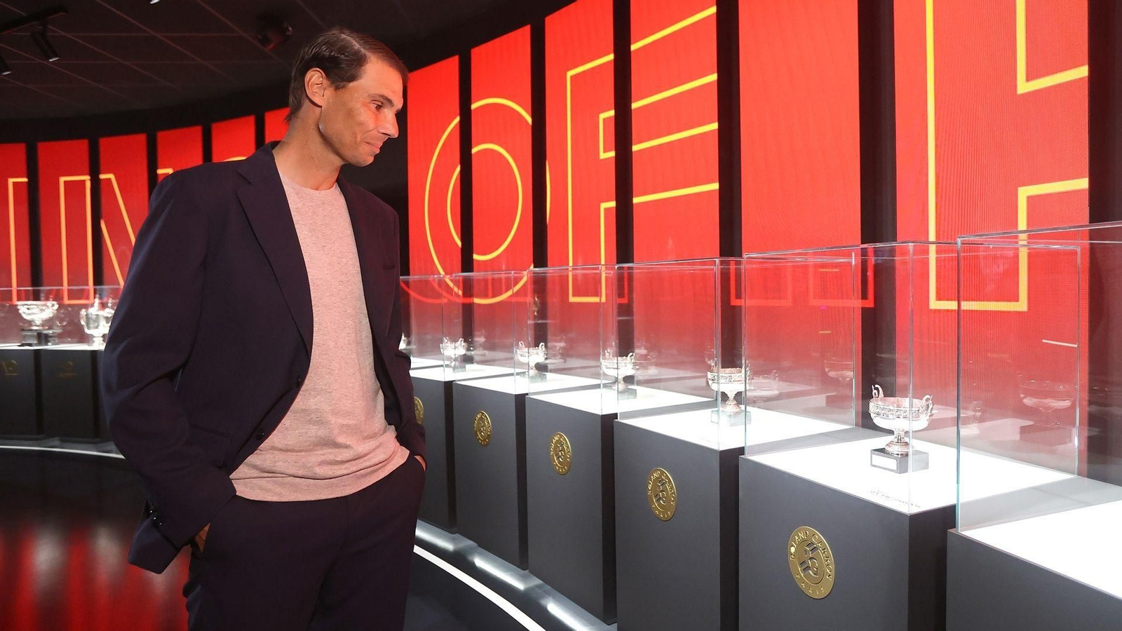 Rafa Nadal observa sus títulos de Roland Garros expuestos en su museo en Manacor.