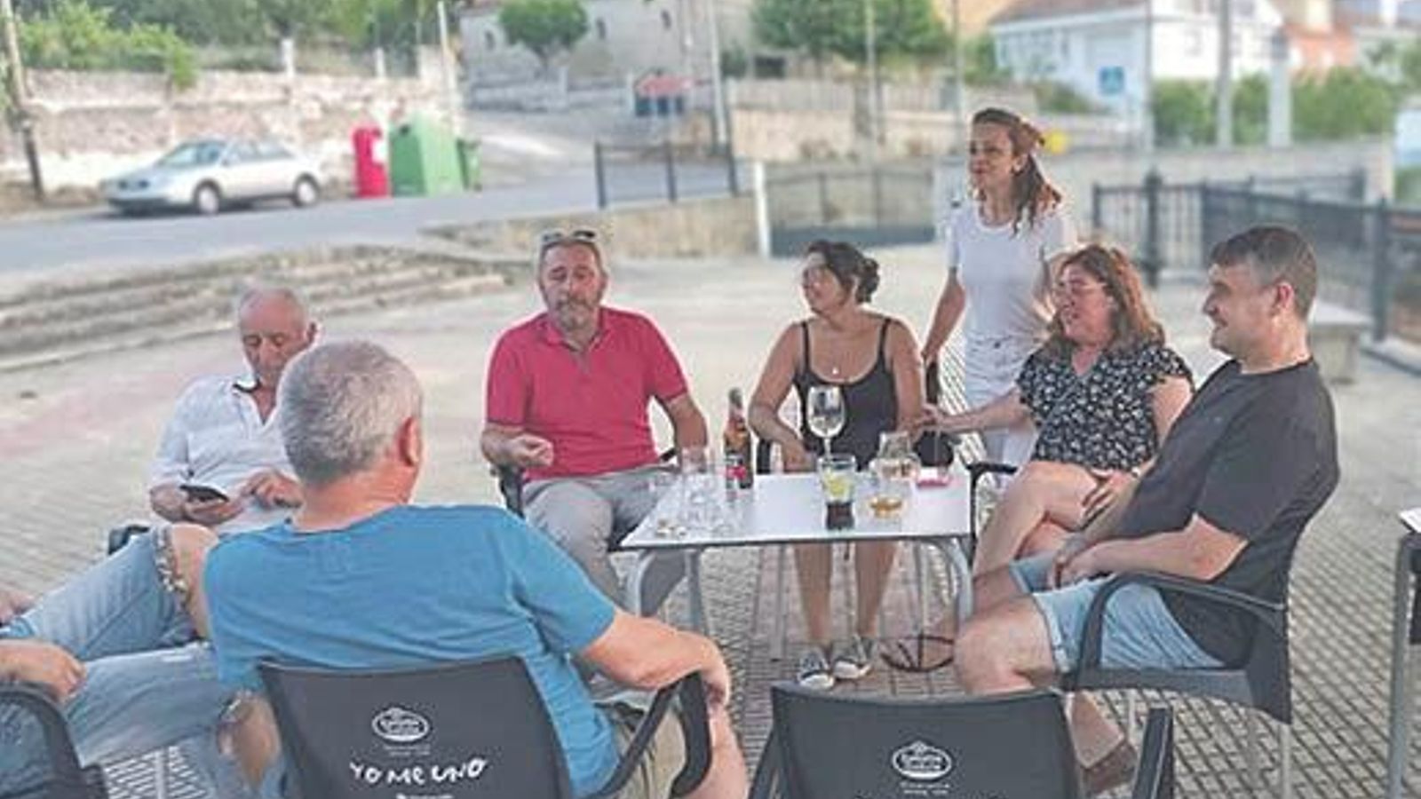 Mónica Francisco (de pie) con sus clientes en la terraza del bar.
