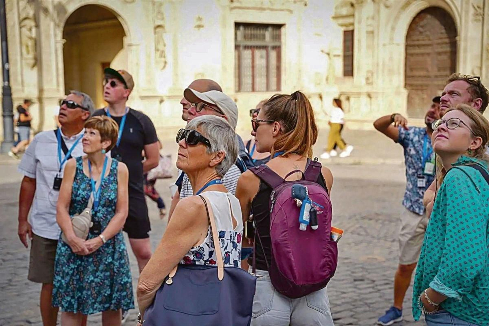 Turistas prestan atención al guía que les explica las curiosidades de la ciudad, en Sevilla.