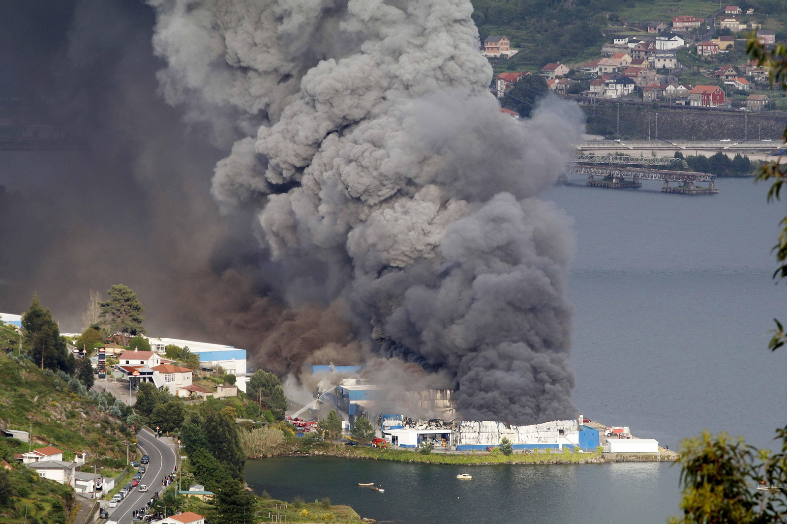La densa humareda, brotando desde la Ría, cubrió el cielo.