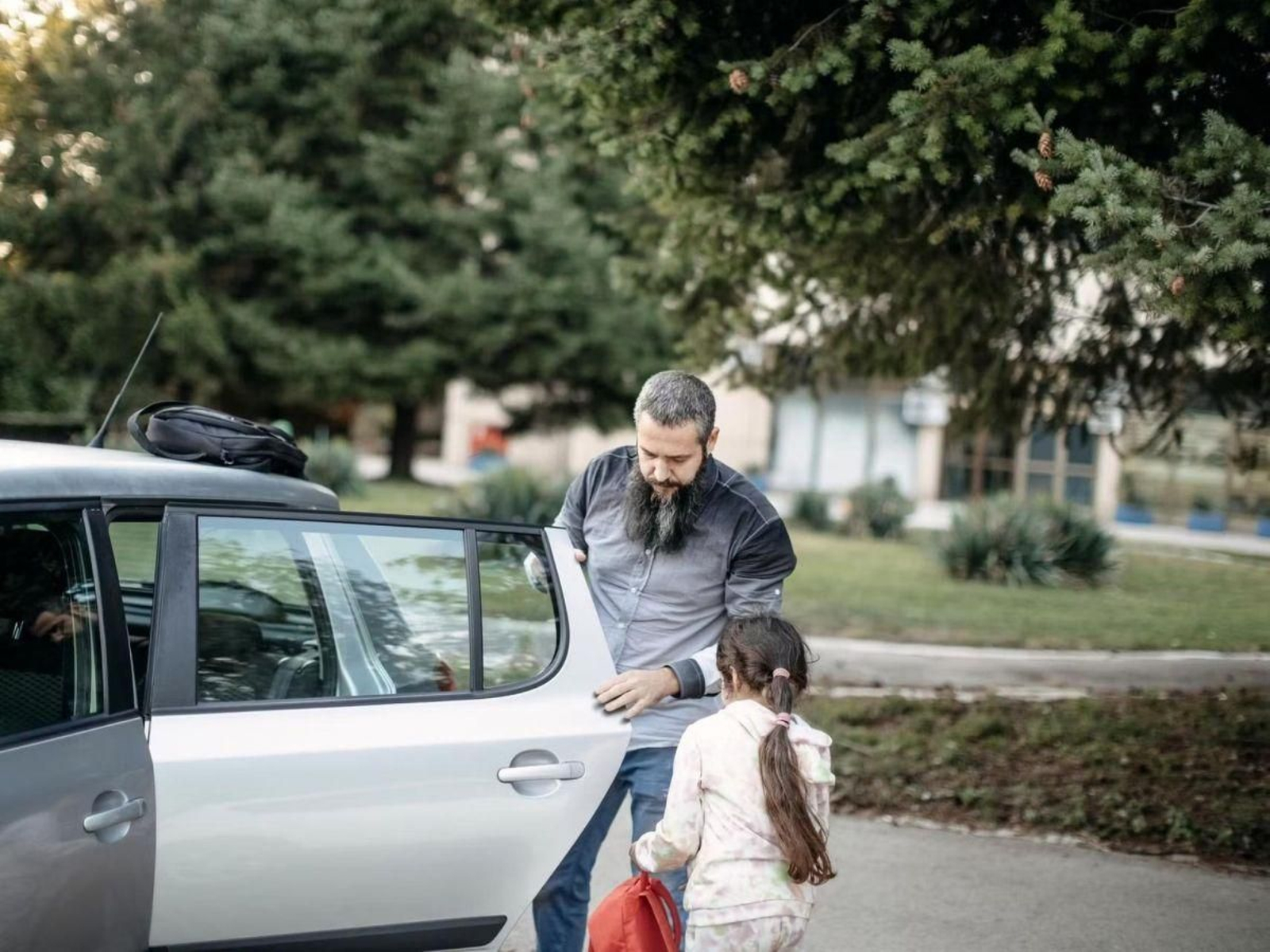 Un padre recoge a su hija a la salida del colegio.