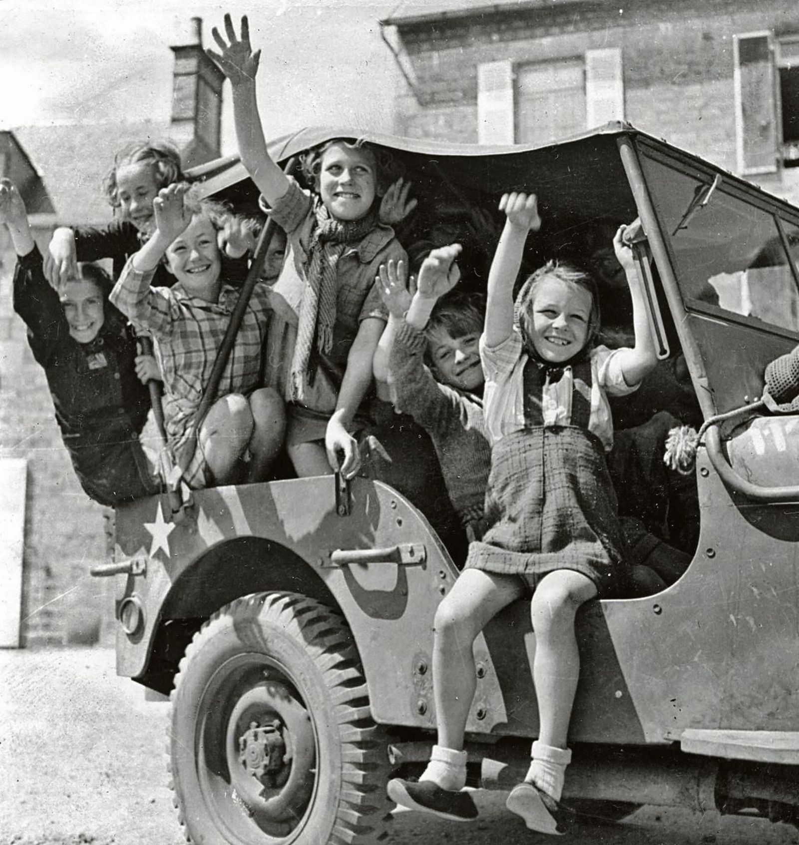 Niños franceses en un coche del ejercito americano después de ser liberados.