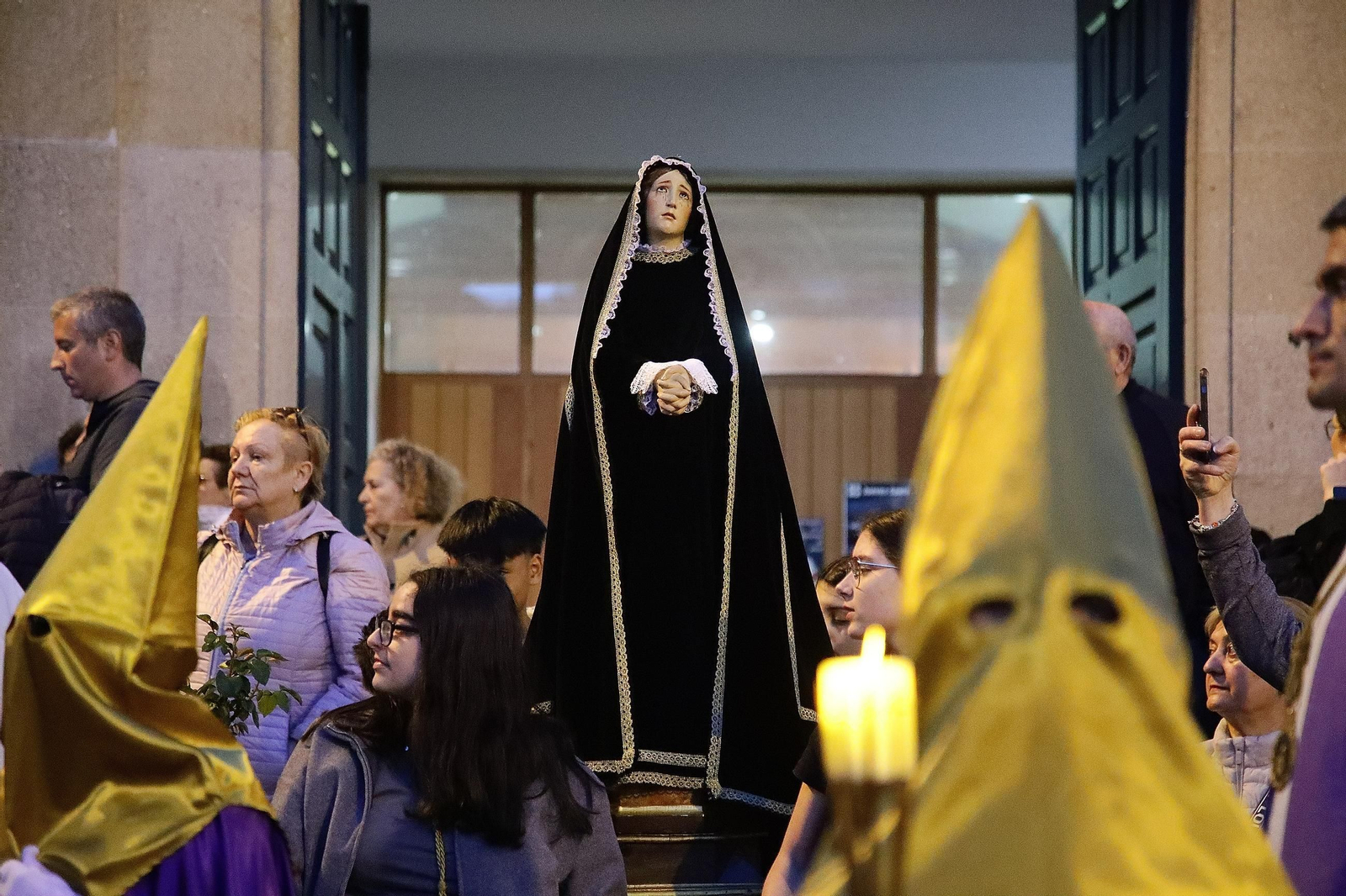 La imagen procesional avanza acompañada por una pequeña multitud.