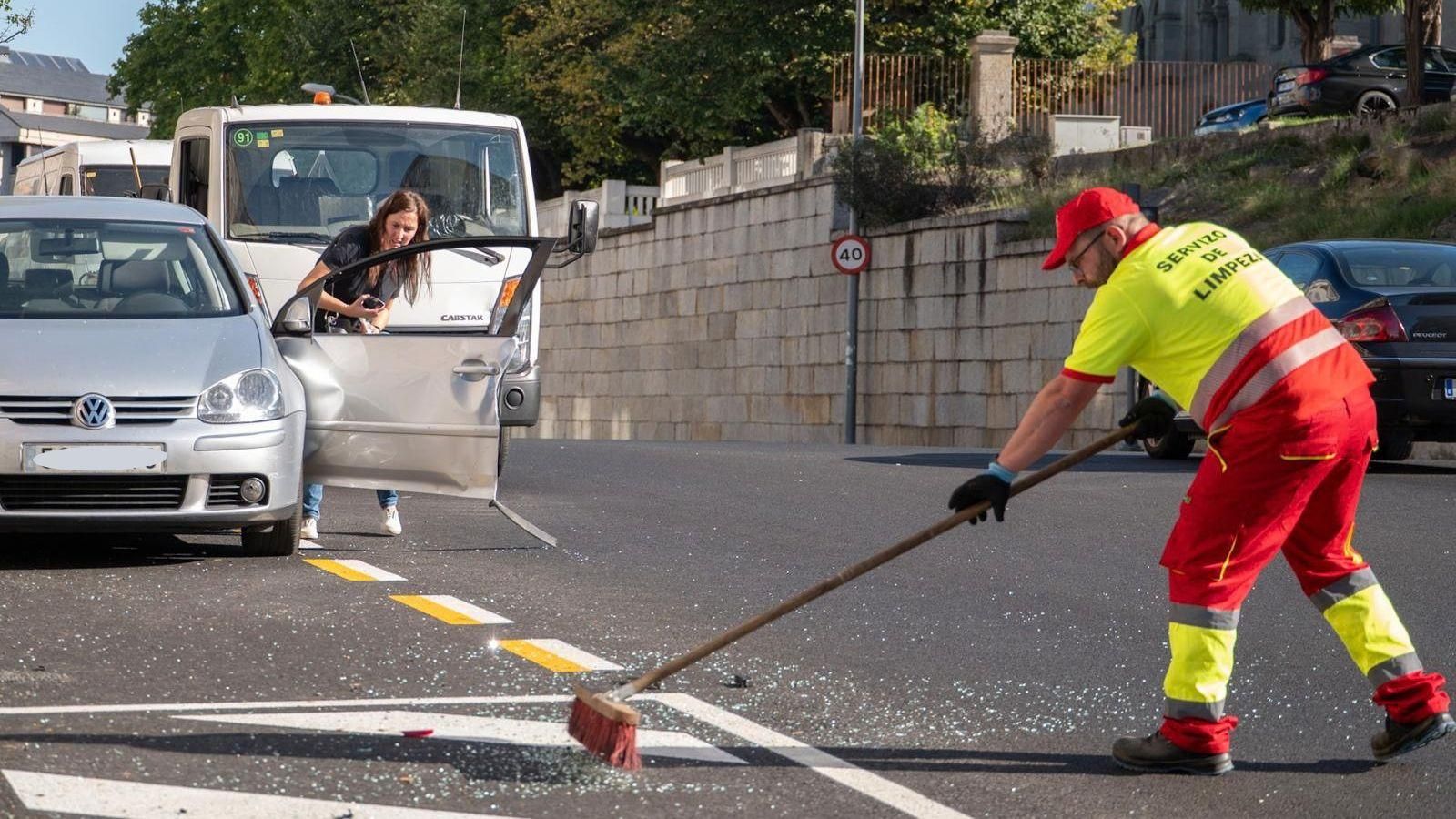 Trabajadores retiran los restos y limpian la calzada tras el accidente ocurrido en la avenida de Pena Trevinca.