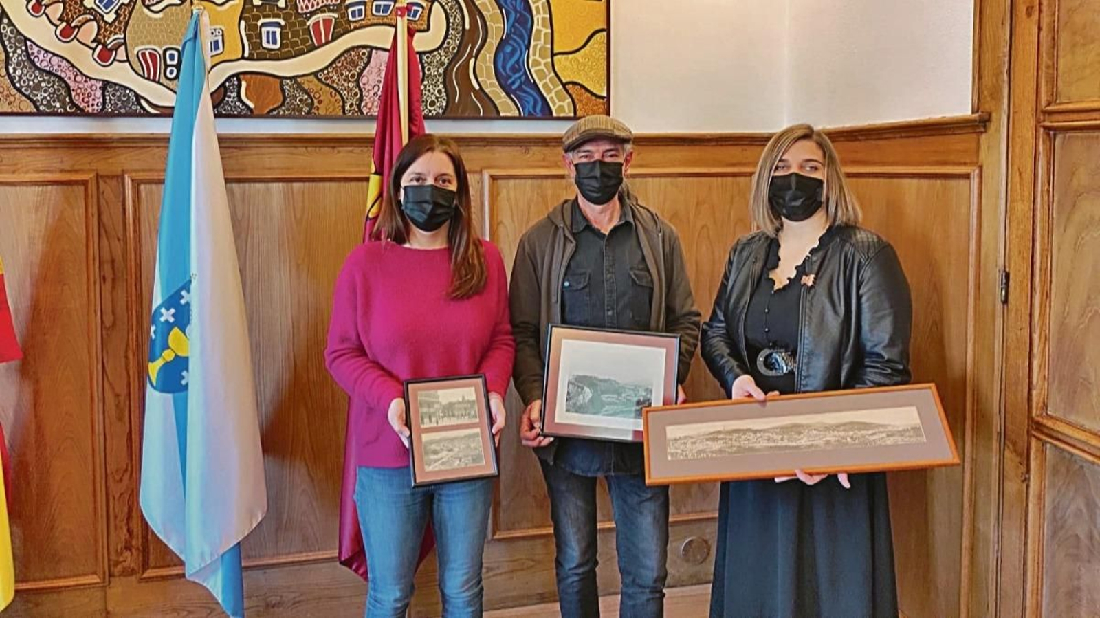 Luis Borines, en el medio, con Ana Gesteria y la concejala Iria Vilaboa, con algunas de las postales.