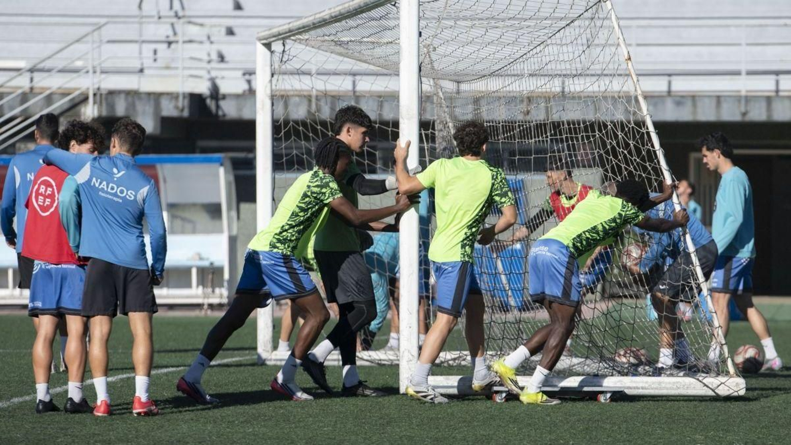 Varios jugadores del Ourense CF colocan una portería durante el entrenamiento en Oira.