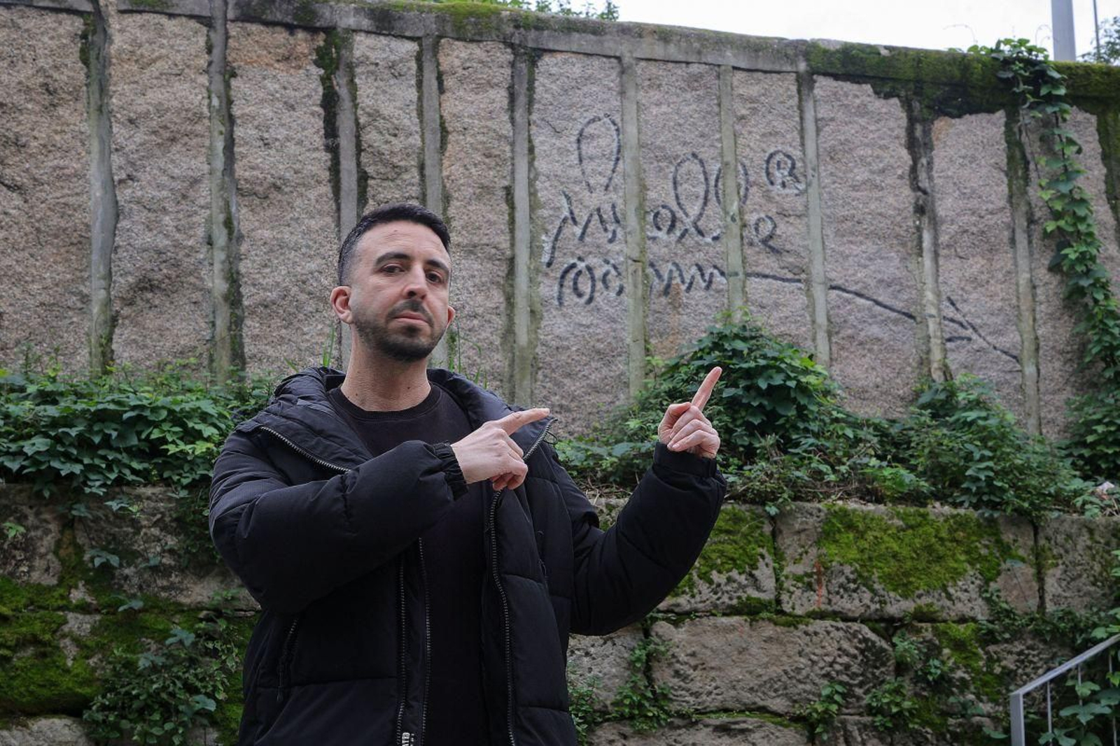 Alberto Santos señala uno de los dos grafitis del Muelle, en Isaac Peral, con su estilo flechero