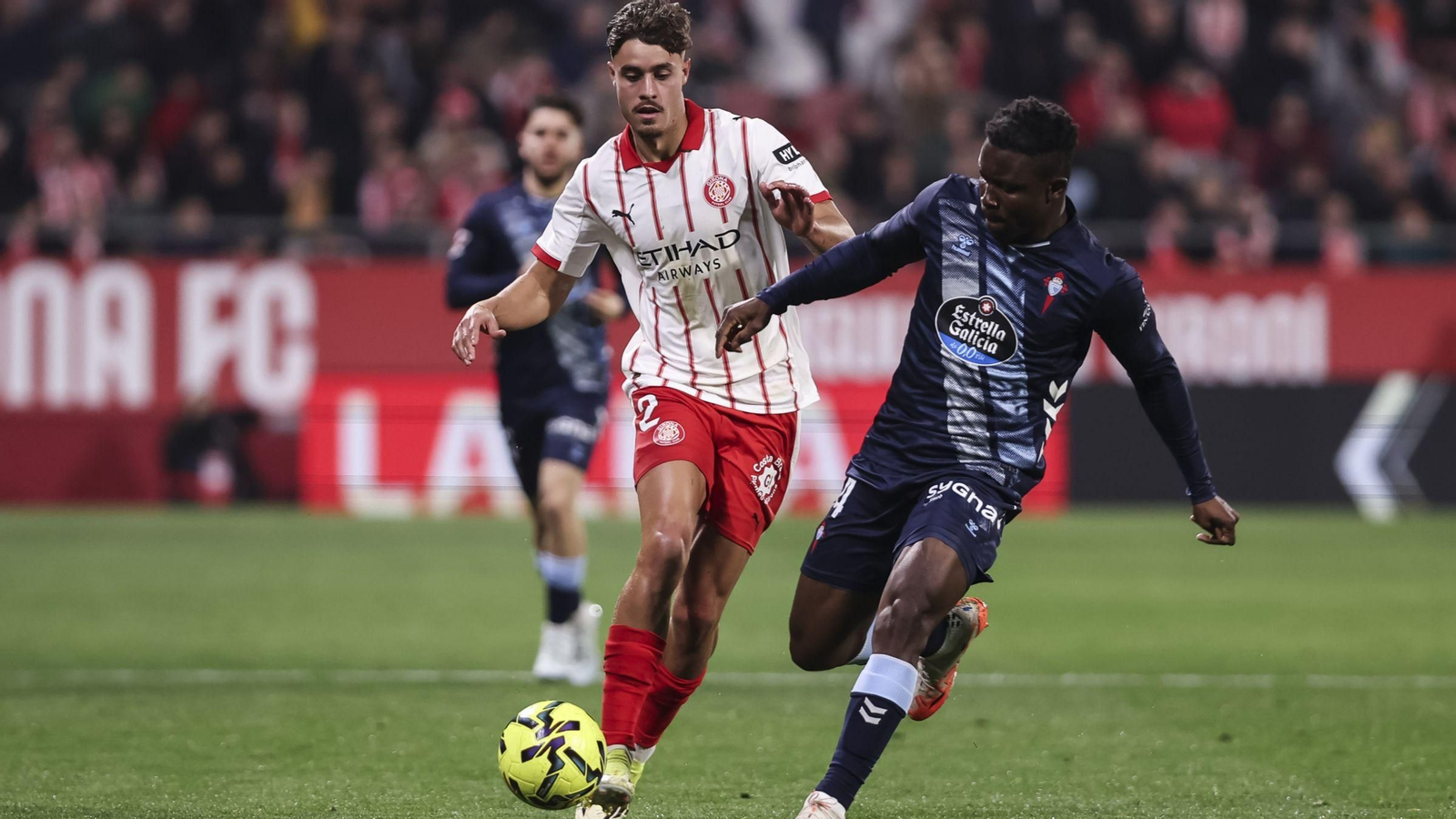 Aidoo persigue el balón con Hugo Rincón al acecho.