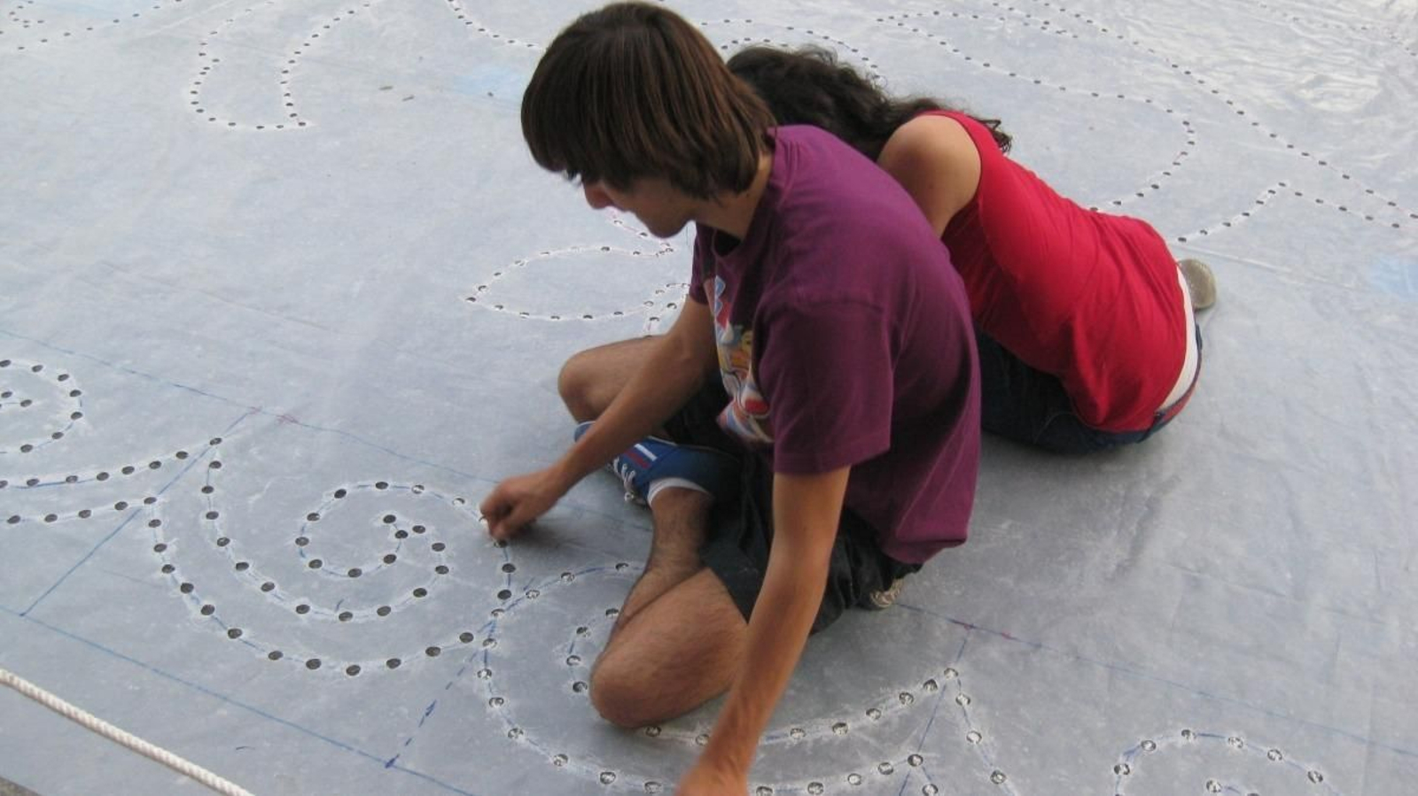 Una alfombra de flores comienza por el plasmado del dibujo en el asfalto y termina siendo una obra de arte.