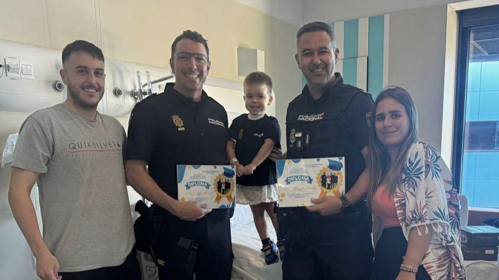 Los agentes de Policá Nacional con el menor y su familia en el hospital.
