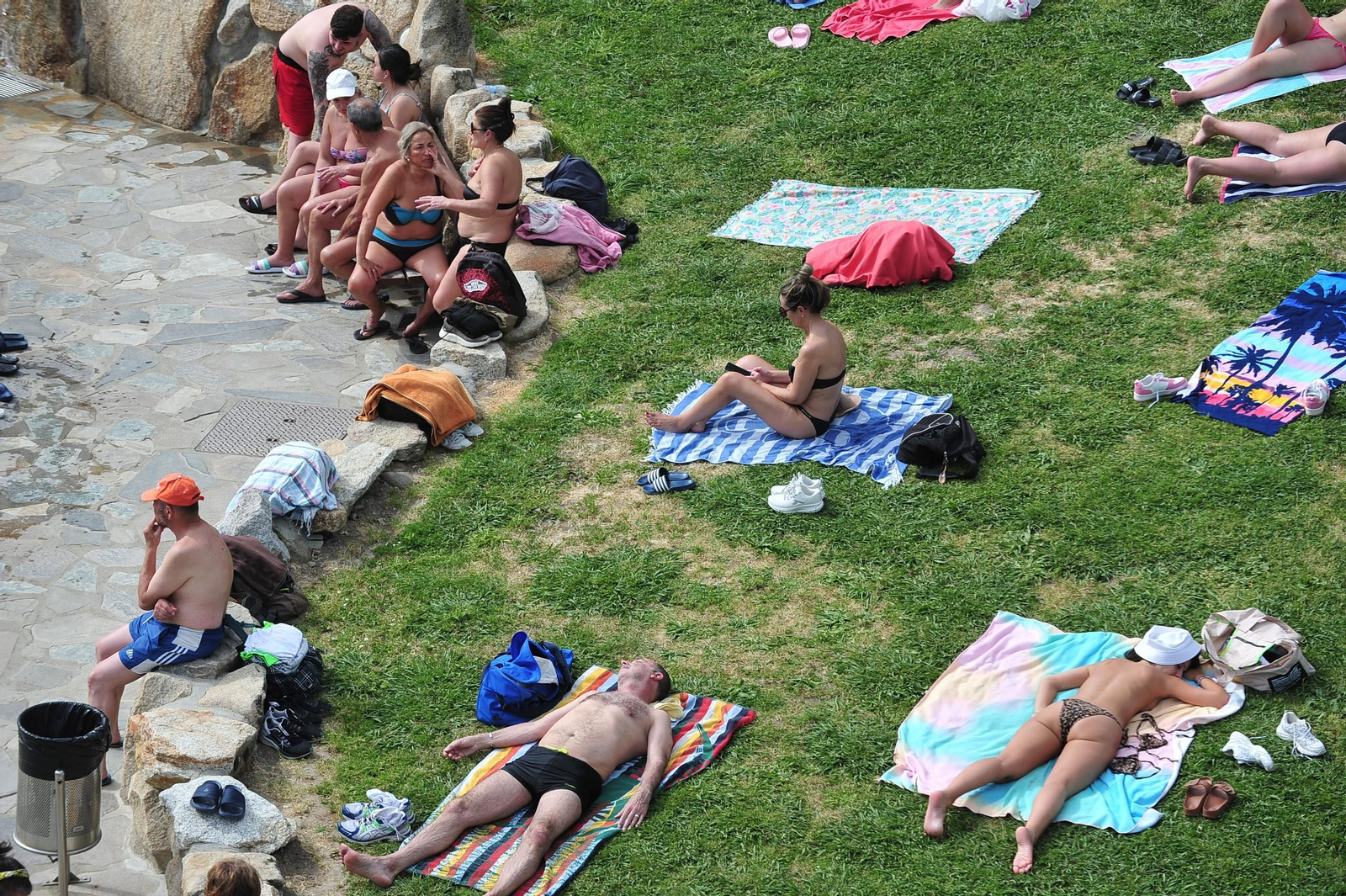 Las tollas sobre el césped de las termas de Outariz para tomar el sol y comenzar a ponerse moreno.