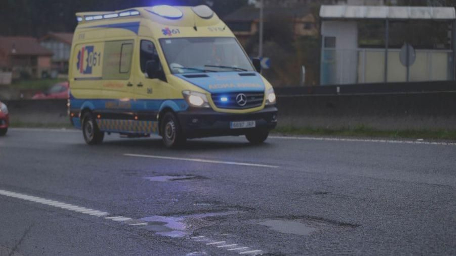 Una ambulancia circula por el kilómetro 10, entre Tameiga y Puxeiros, poblado de baches.