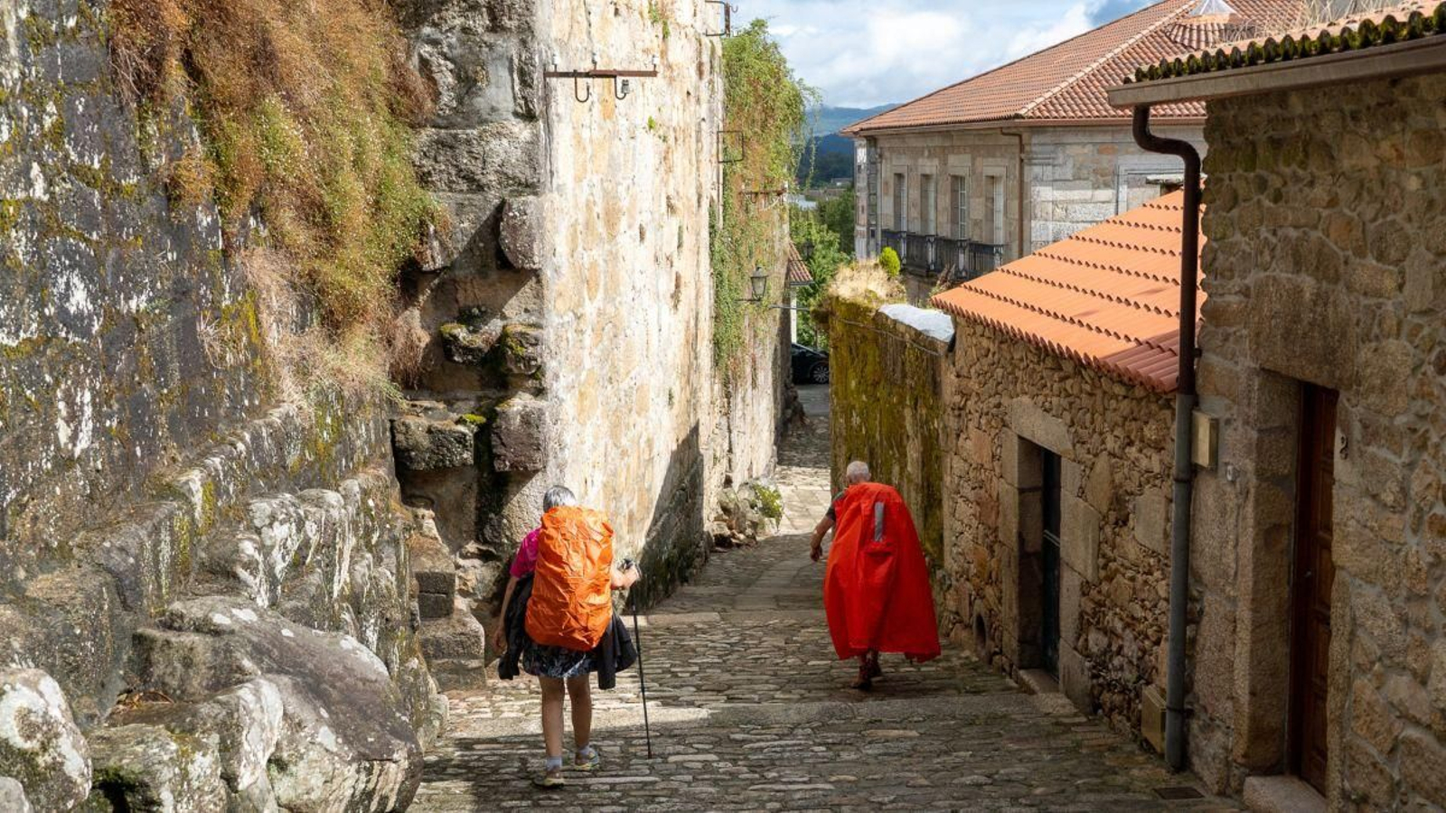 Peregrinos del Camino Portugués cruzando el centro histórico de la ciudad de Tui.