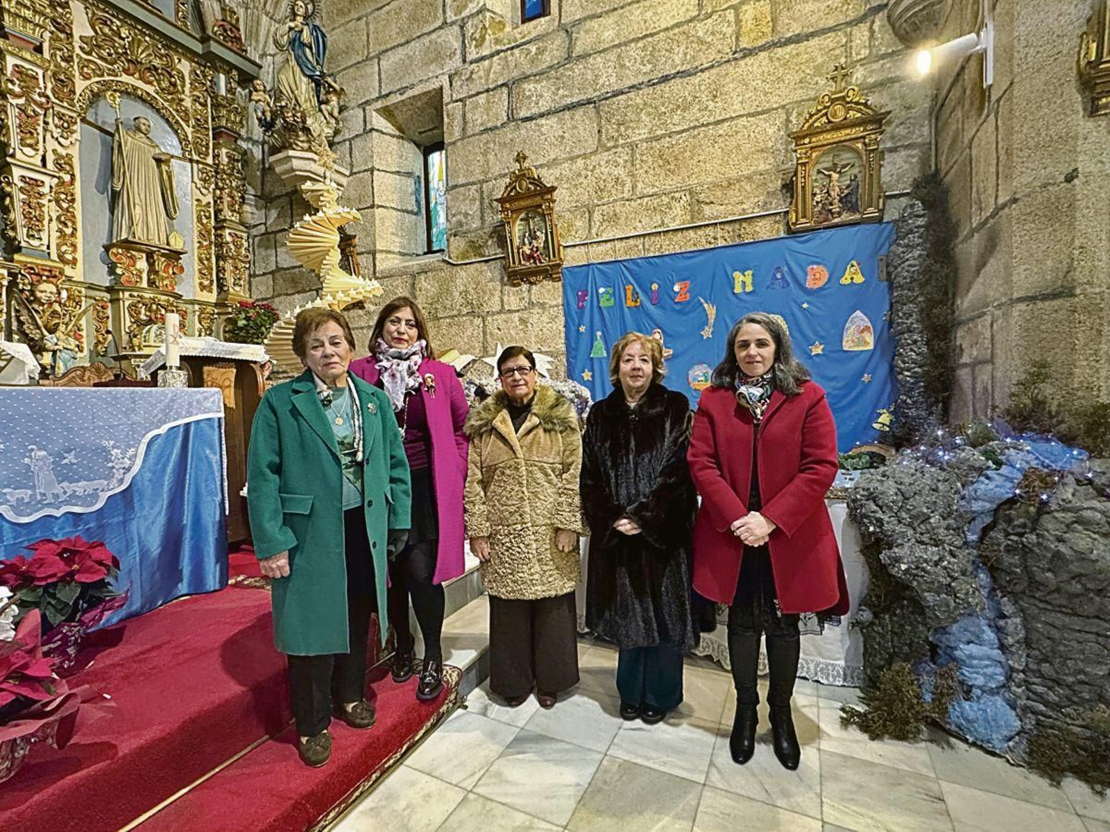 Algunas de las vecinas que realizan el belén en la iglesia parroquial de Beariz.