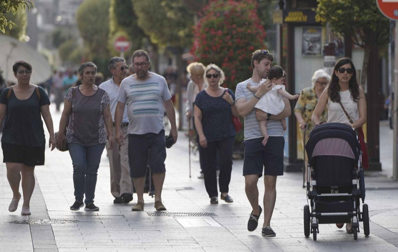 Familias viguesas con niños pequeños por la peatonal del Calvario.