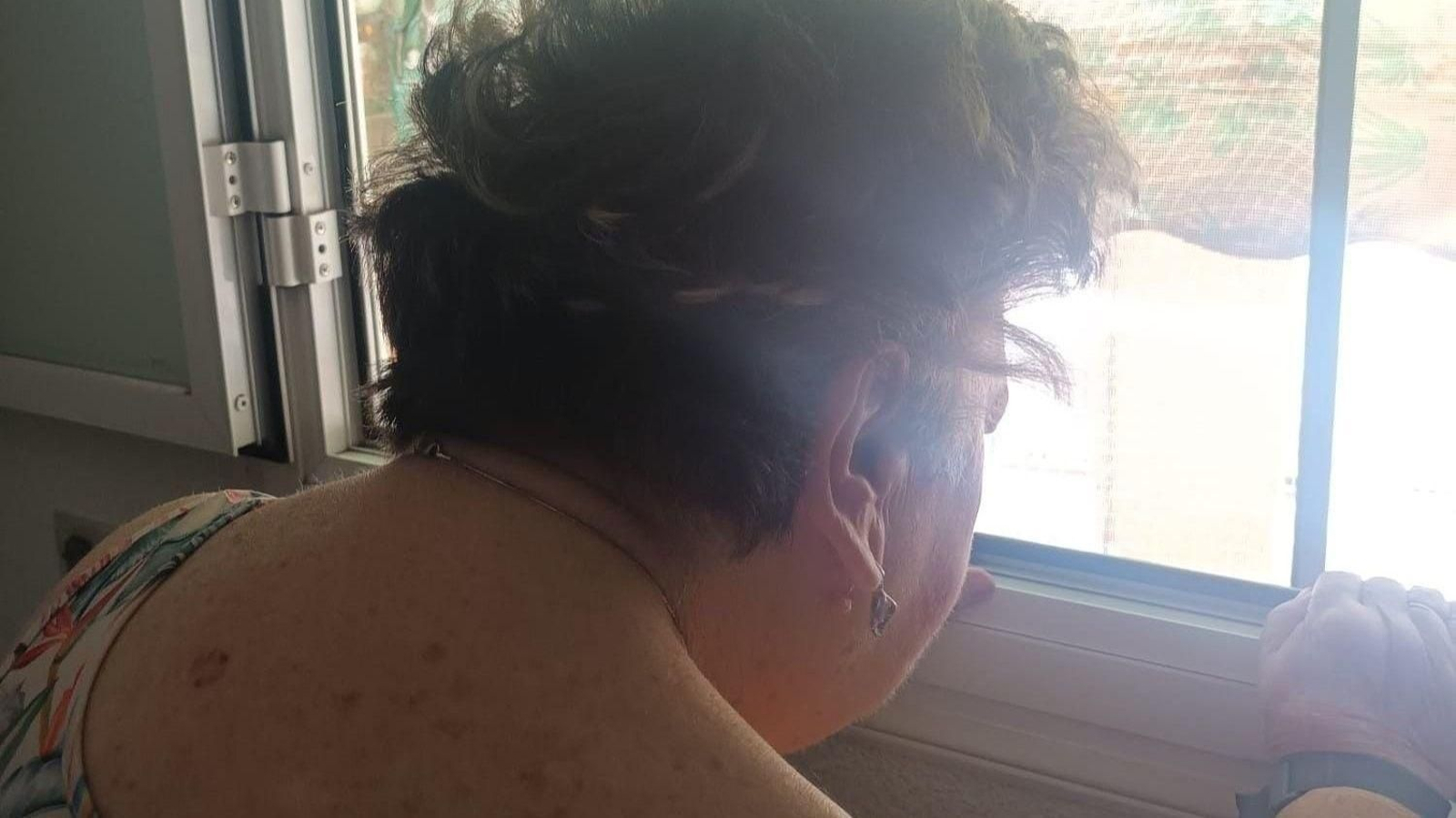 Teresa se asoma a la ventana de su casa.