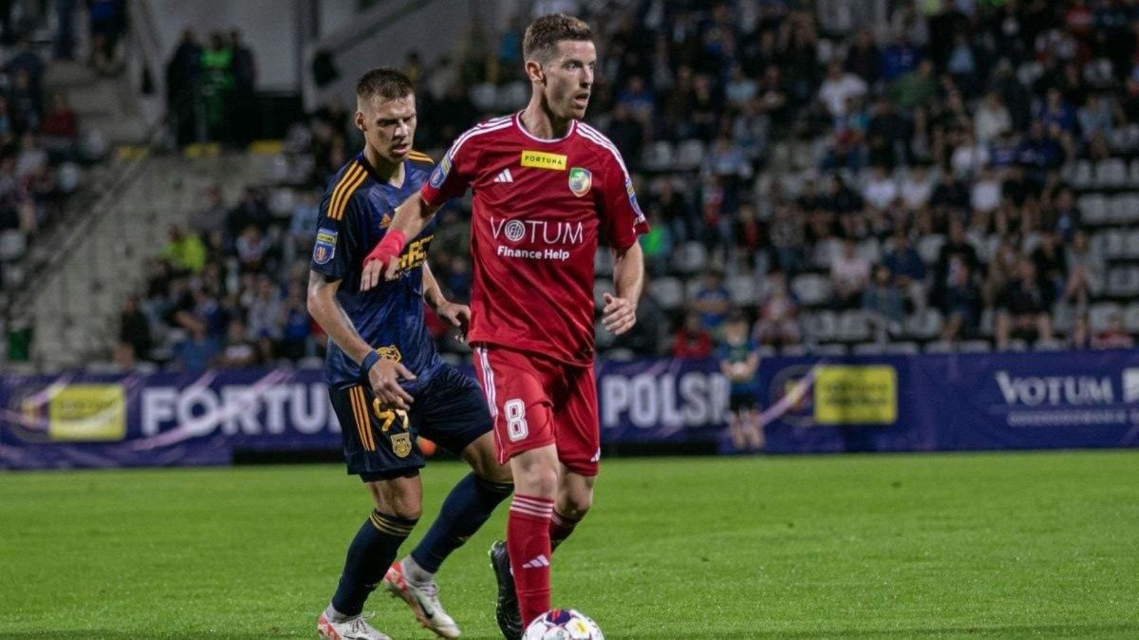 Tarsi Aguado, en su época como centrocampista del Miedz Legnica, aguanta el balón ante un contrario.
