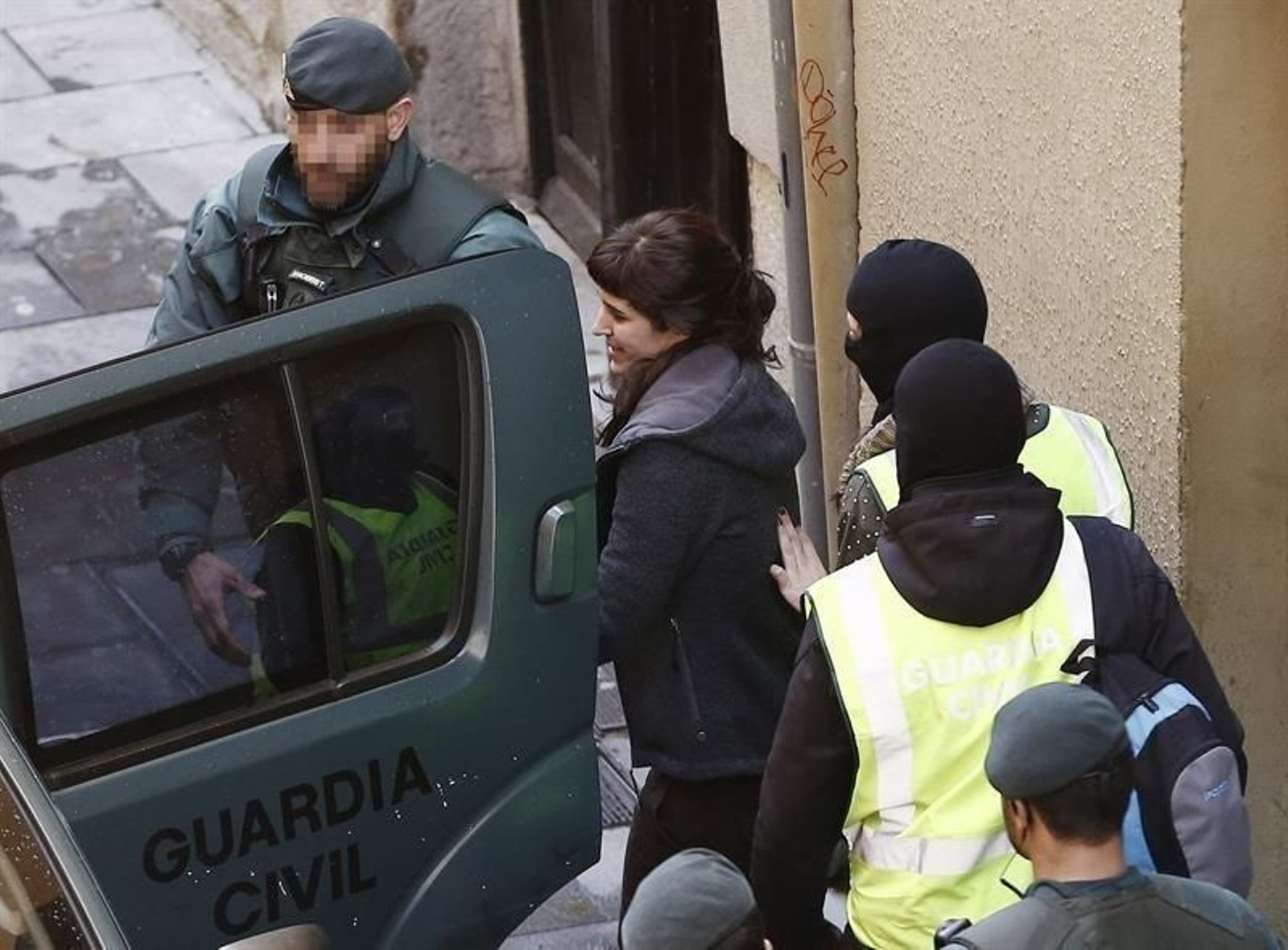 Efectivos de la Guardia Civil llevan hacia el vehículo policial a Oihana Barrios Salinas despues de efectuar el registro en su domicilio.