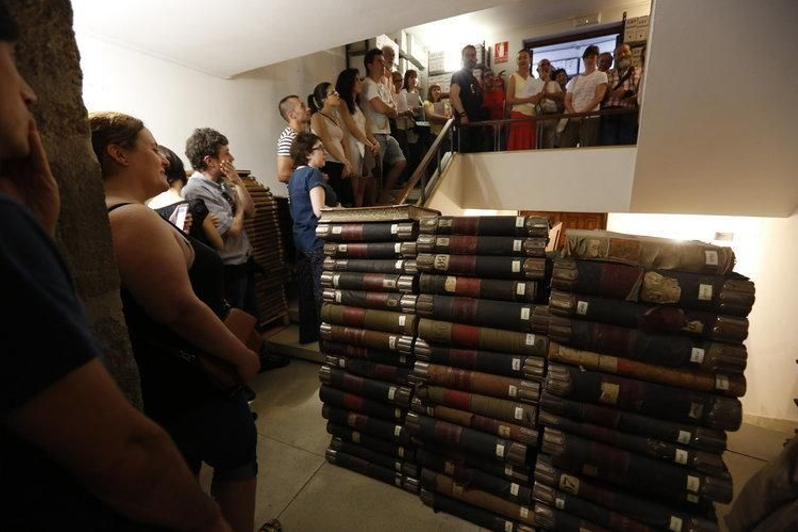 Una cola de visitantes, en las jornadas de puertas abiertas, al lado de documentos apilados en el suelo.