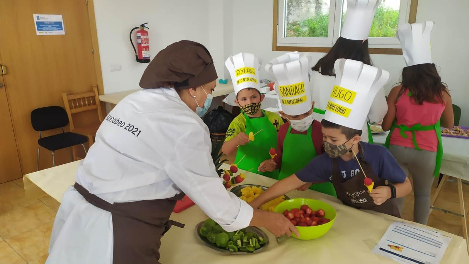 Varios menores durante la preparación de las brochetas de frutas.