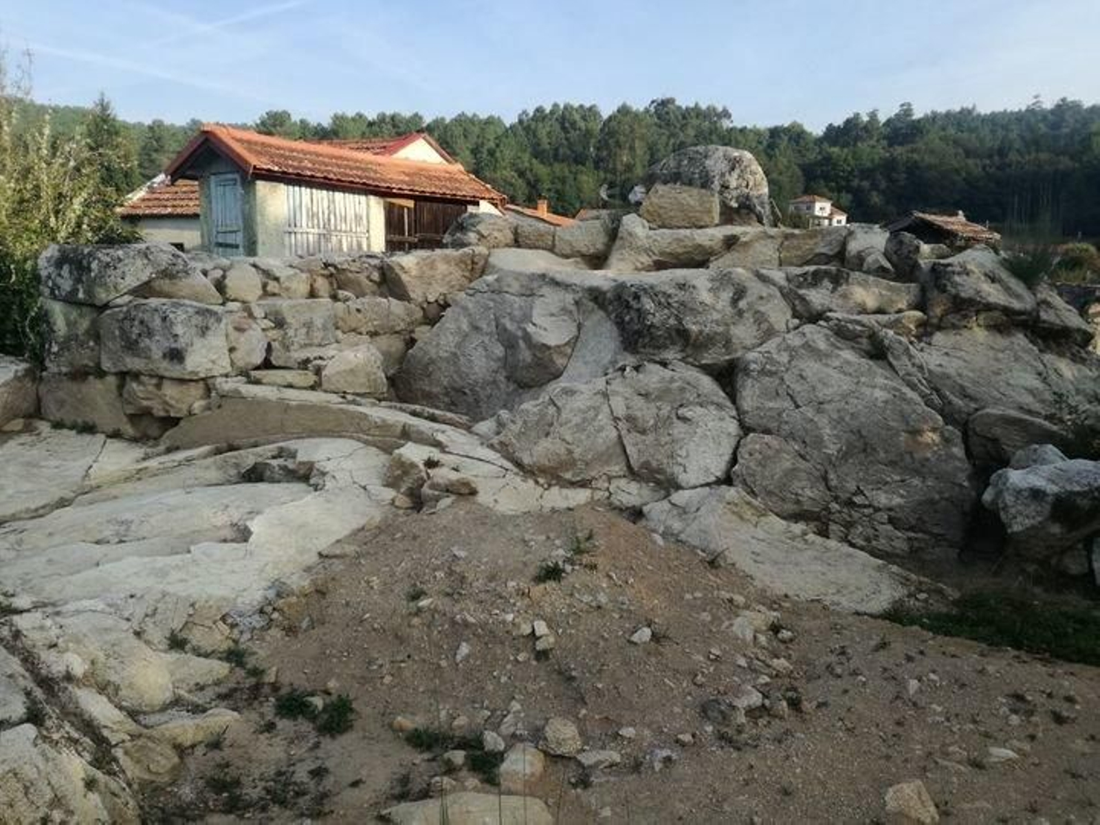 Muros descubertos na Torre de Godás, co pozo, tapado, á dereita da imaxe.