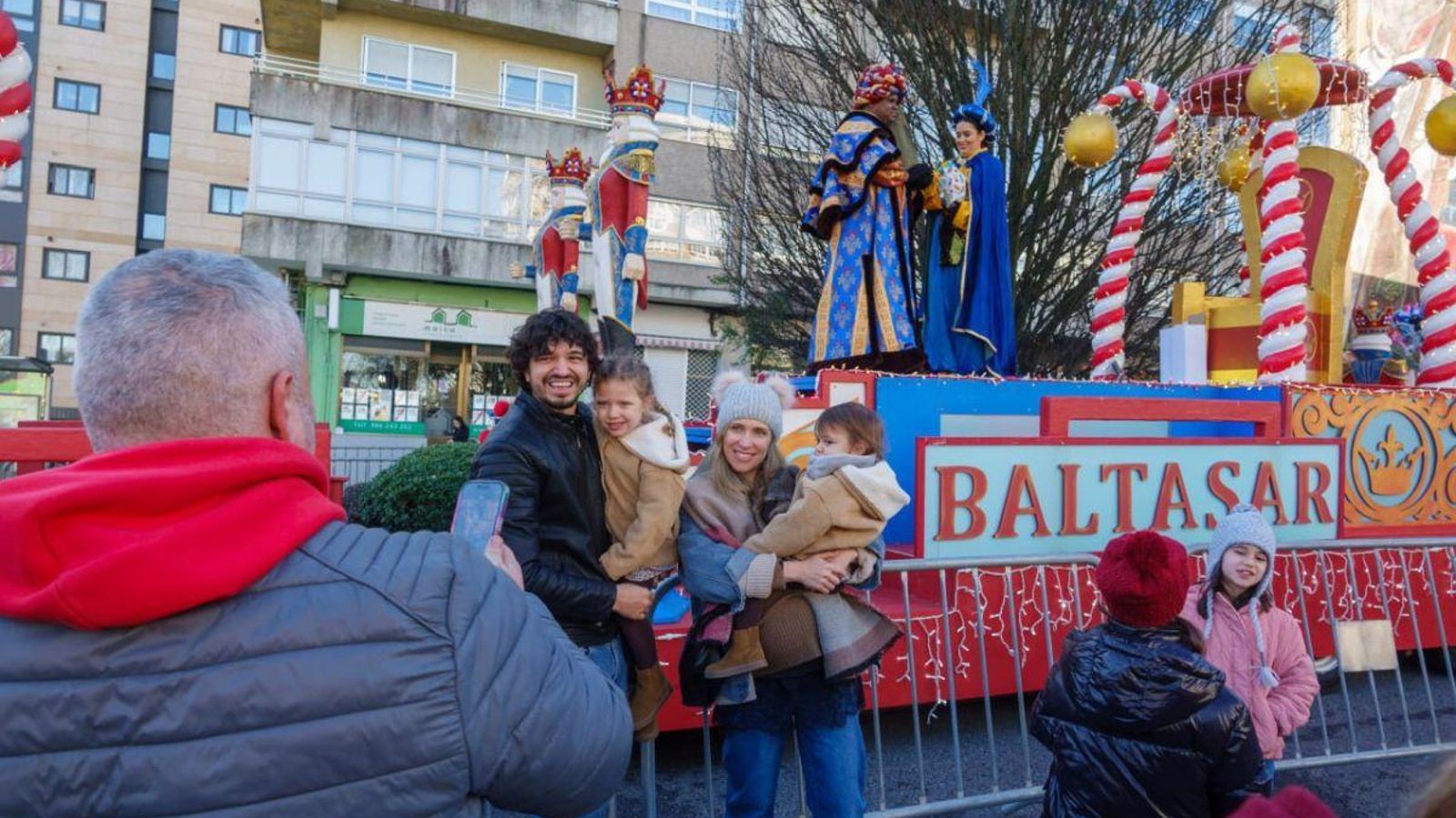 Una familia, feliz frente a la carroza de Baltasar en la cabalgata estática de Coia.