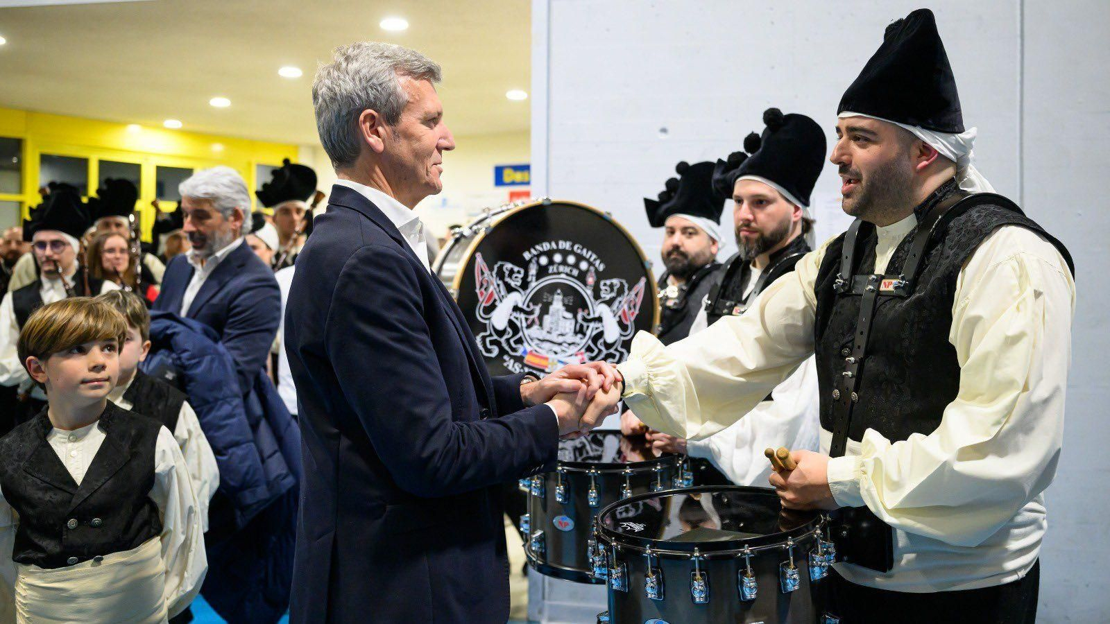 El presidente de la Xunta, Alfonso Rueda, saluda a los integrantes del grupo folklórico As Xeitosiñas durante el encuentro con la colectividad gallega en Zúrich.