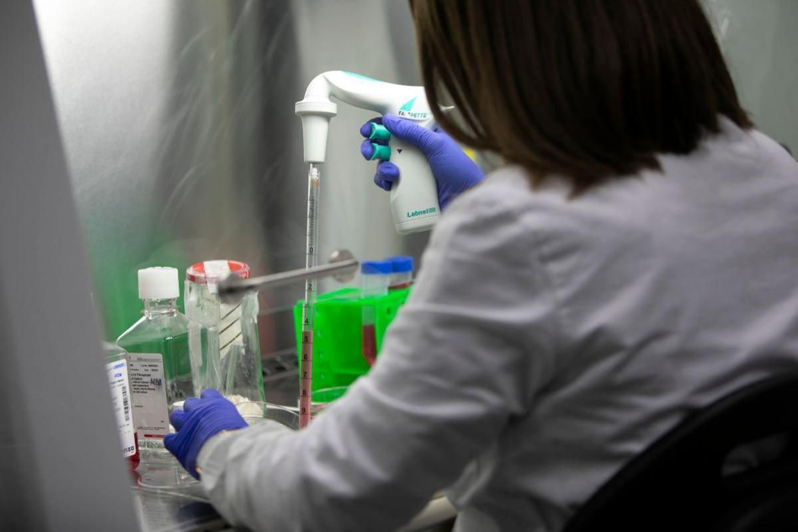 Una investigadora tomando muestras en un laboratorio.