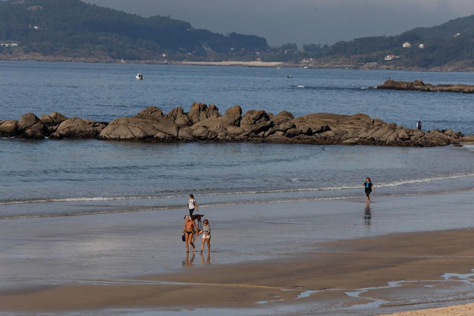 Más gente paseando sobre la arena de Samil.