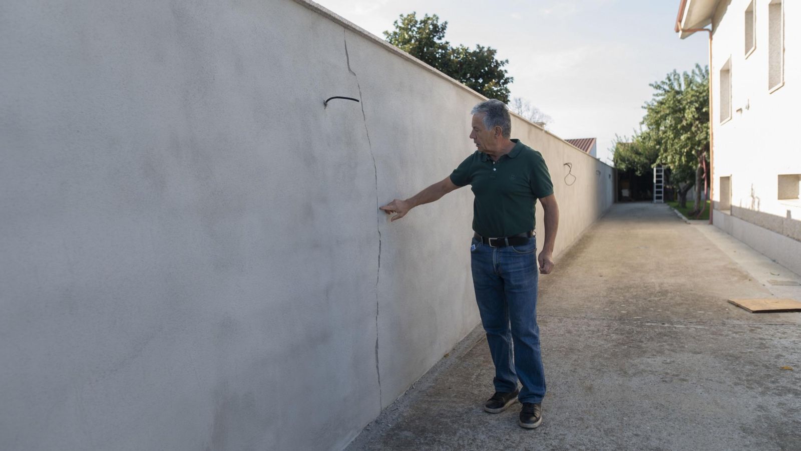 Ángel Garrido muestra una grieta reciente en el muro de su casa.