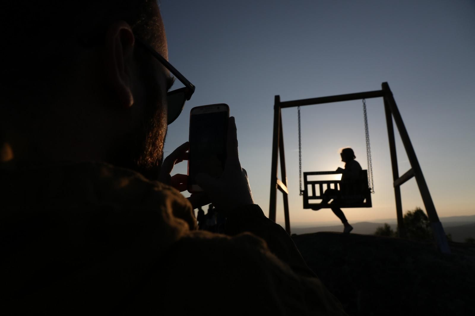 Un joven fotografía el atardecer en el Bambán do Solpor, en la Ribeira Sacra.