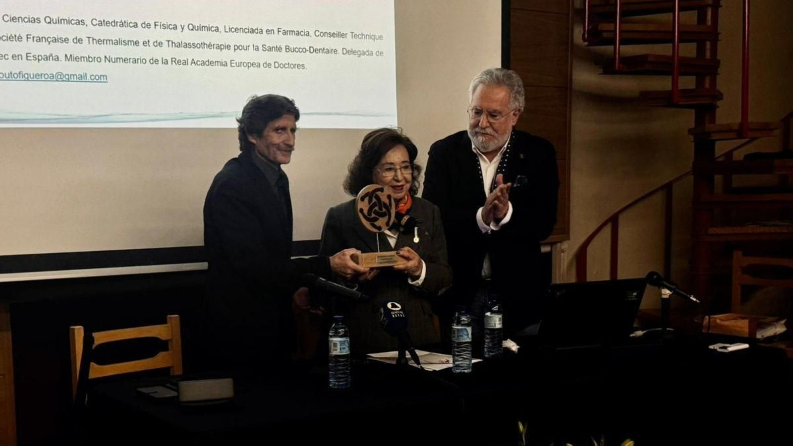 Carlos Rodríguez entrega el galardón a Marita Souto ante la mirada de Miguel Santalices.