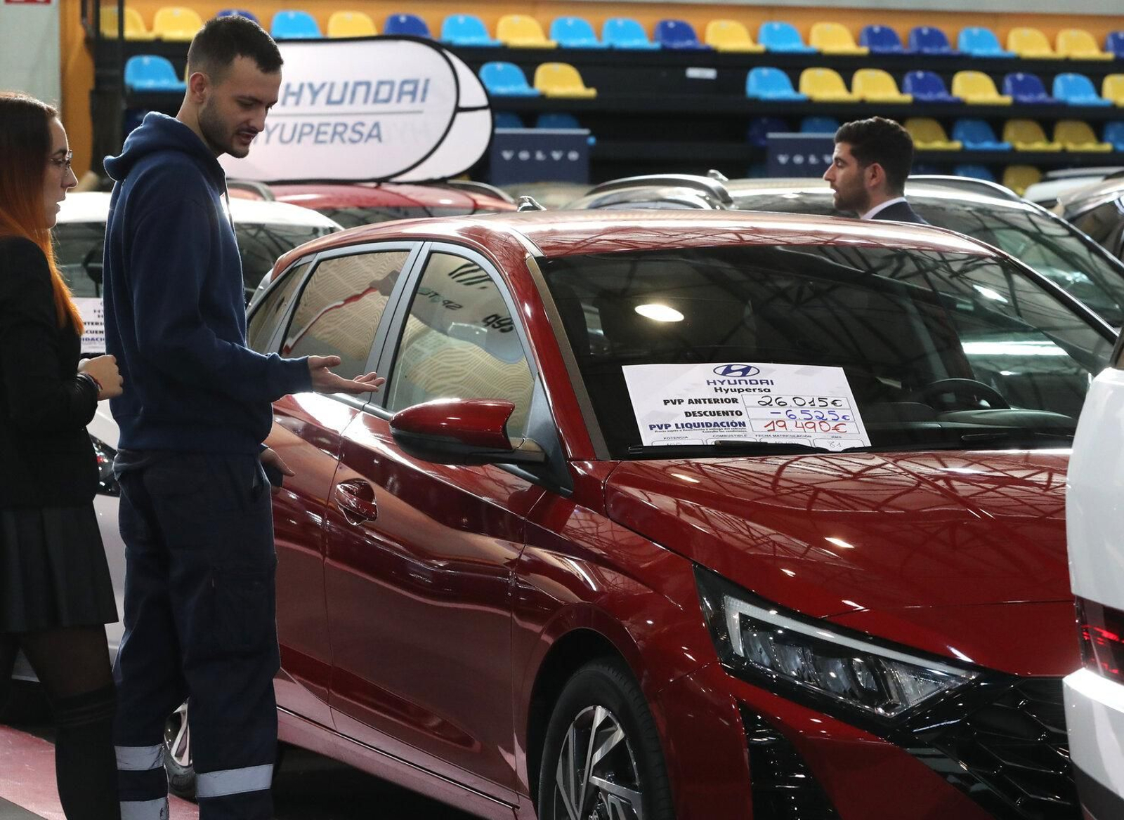 Visitante de la exposición entrando a probar por dentro uno de los coches