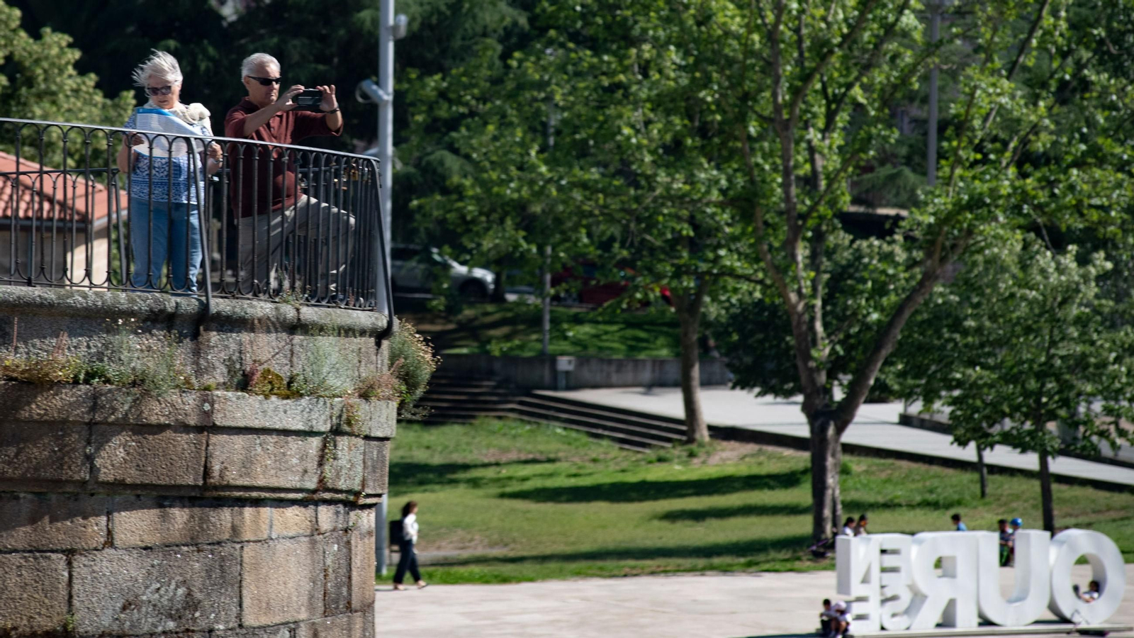 Dos turistas disfrutan del buen tiempo en Ourense.