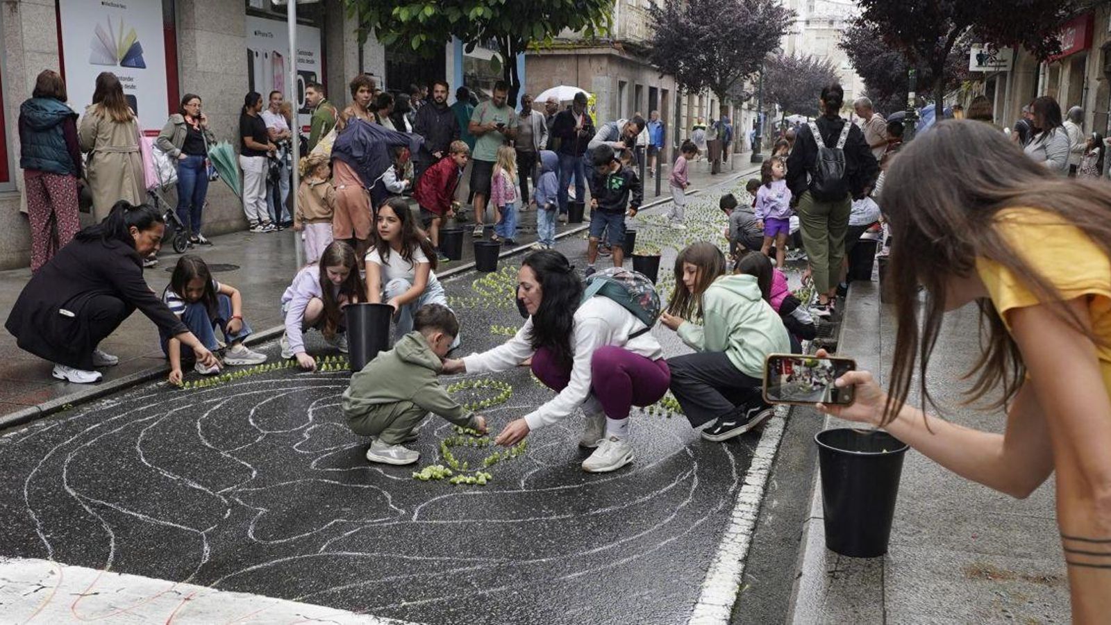 Un grupo de niños ayudando a la elaboración de las alfombras en Redondela.