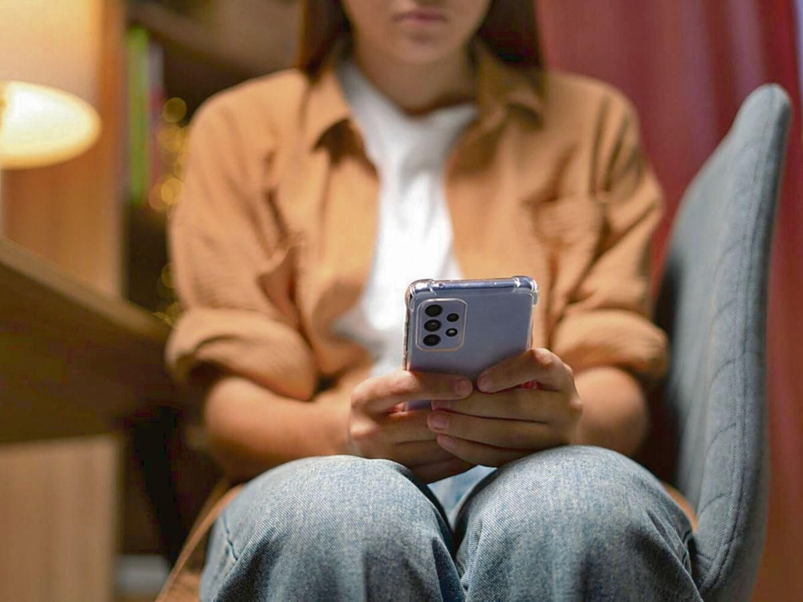 Una joven revisa su teléfono móvil.