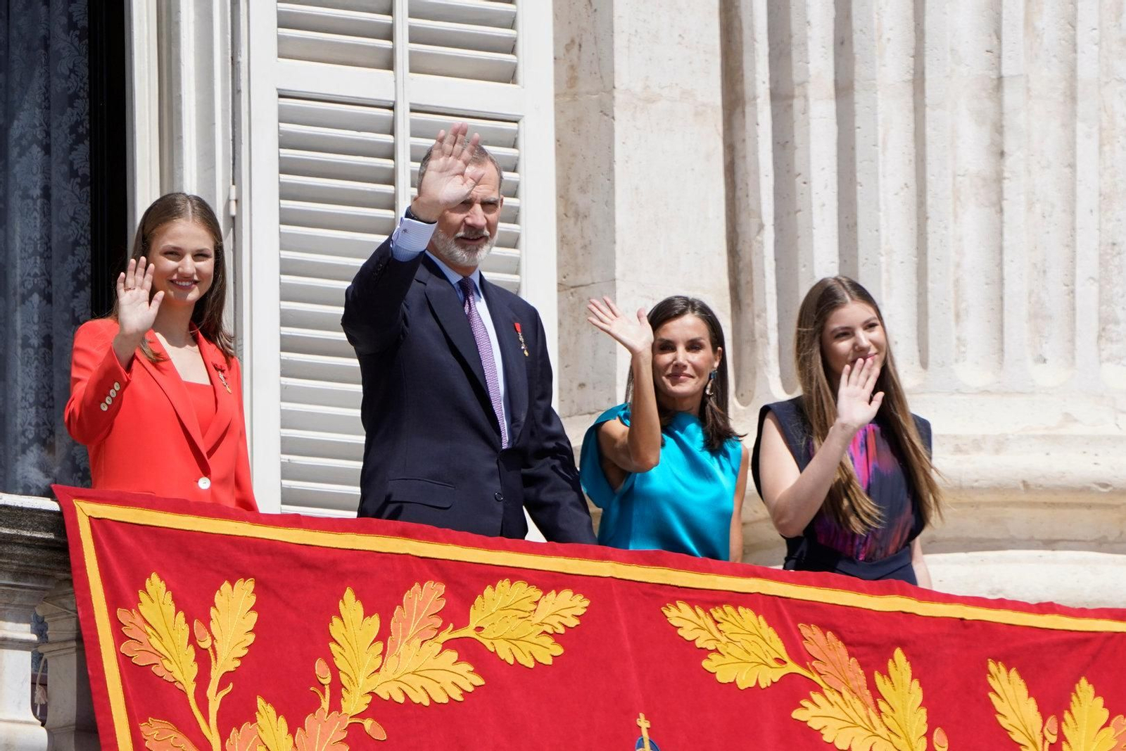 Los Reyes y sus hijas saludan desde el balcón del Palacio Real.