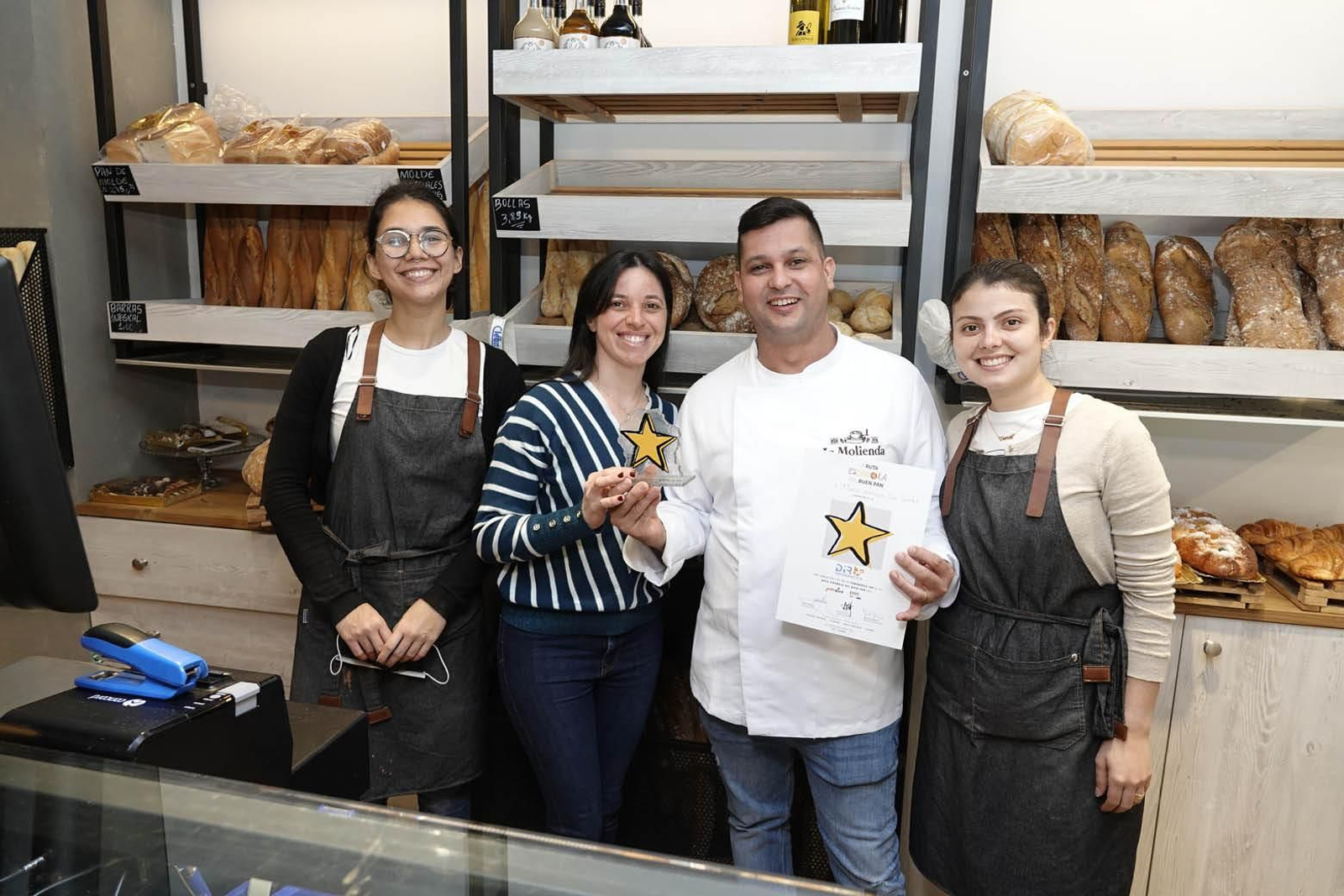 Flavio Henrique posa con la Estrella DIR y con el resto de empleadas de la panadería.